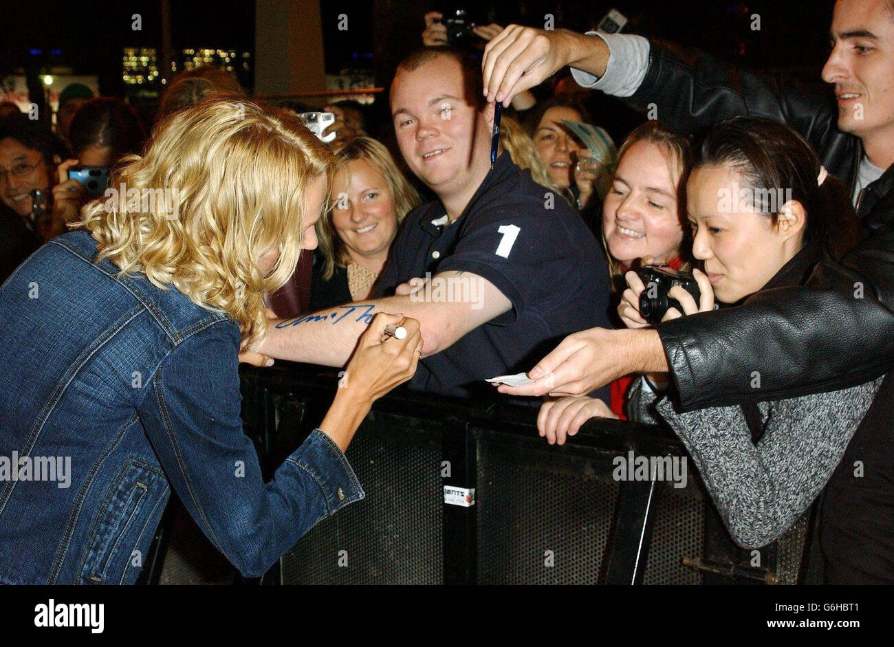 Uma Thurman gibt Autogramme für Fans, als sie die britische Premiere von Kill Bill - Volume 1 am Empire Leicester Square im Zentrum von London verlässt. Der zweiteilige Film ist vom Regisseur Quentin Tarantino und wird bundesweit am Freitag, den 17. Oktober 2003, eröffnet. Stockfoto