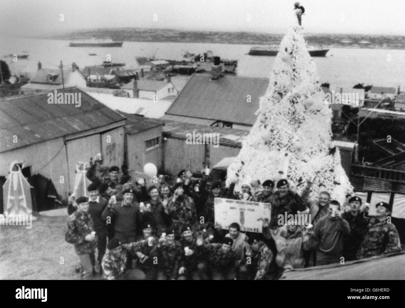 Bomb Disposal Männer der British Army Royal Engineers machen eine Pause von der Räumung der Minenfelder, wo Sonntag und posieren neben einem hausgemachten Weihnachtsbaum mit einer Nachricht für Familie und Freunde in Großbritannien . 20. Dezember 1982 Stockfoto