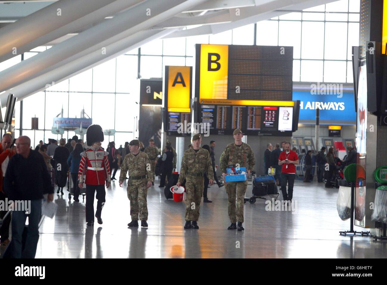 Soldaten, die am Londoner Mohn-Tag der Royal British Legion (RBL) im Terminal 5 am Flughafen Heathrow in London Mohnblumen verkaufen. Stockfoto