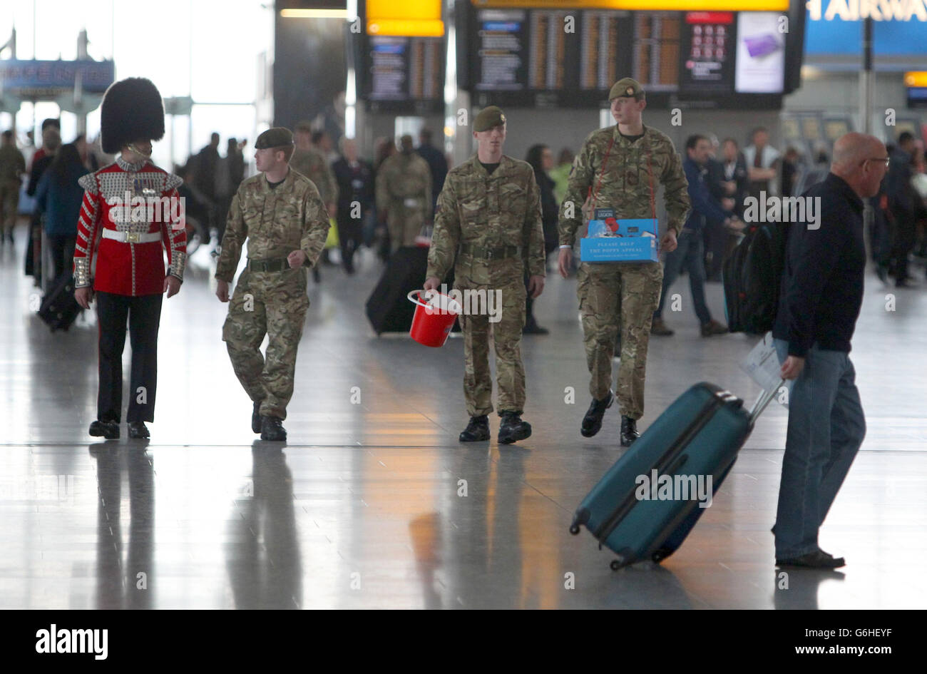 Soldaten, die am Londoner Mohn-Tag der Royal British Legion (RBL) im Terminal 5 am Flughafen Heathrow in London Mohnblumen verkaufen. Stockfoto