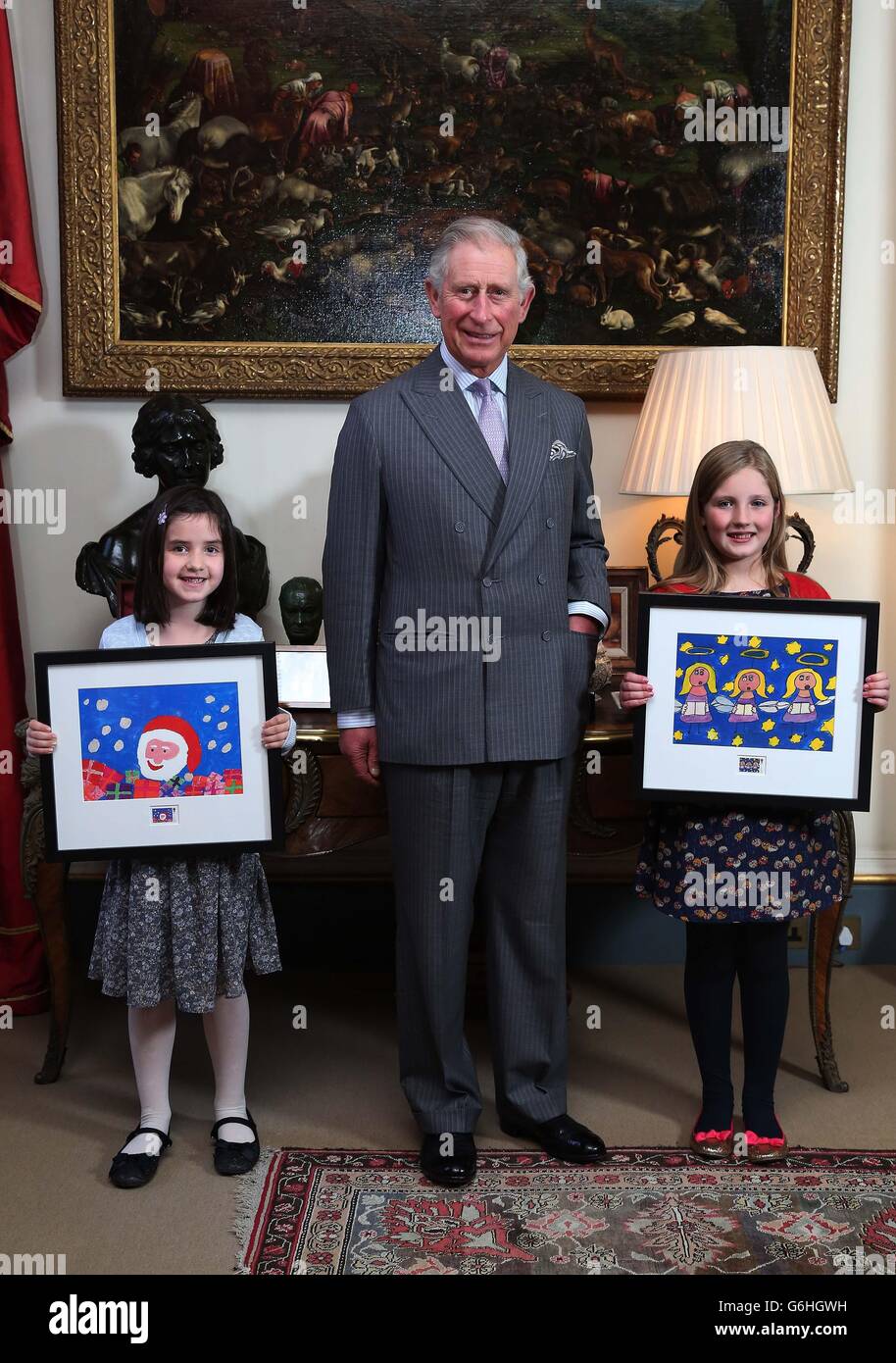 Prinz Charles präsentiert Molly Robson (links), sieben Jahre alt, die Schülerin an der Leechpool Primary School in Horsham, West Sussex, und Rosie Hargreaves (rechts), 10 Jahre alt, Die Ermington Primary School in Ivybridge, Devon besucht, mit gerahmten Kopien ihrer Gewinnerentwürfe des Royal Mail's Christmas Stamp Design Competition, im Clarence House im Zentrum von London. Stockfoto