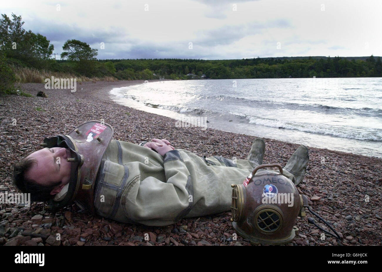 Wohltätigkeitswanderer Lloyd Scott entspannt sich am Ufer des Loch Ness, nachdem er den letzten Teil seines Unterwasser-Marathons absolviert hat. Scott hat in den vergangenen zwei Wochen einen 26 Meilen langen Abschnitt des trüben Highland loch durchforst. Aber die Herausforderung war nicht ohne ihre Probleme. In der vergangenen Woche fiel der 41-Jährige unter Wasser von einem 15 Meter hohen Vorsprung, wobei er sich dabei die Schulter verletzte, beschloss aber, am nächsten Tag seine Herausforderung zu bewältigen. Der ehemalige Feuerwehrmann und Profi-Fußballspieler verbrachte mehr als einen Monat damit, sich als Taucher für das Angebot zu qualifizieren, um Geld für die Wohltätigkeitsorganisation Children With zu sammeln Stockfoto