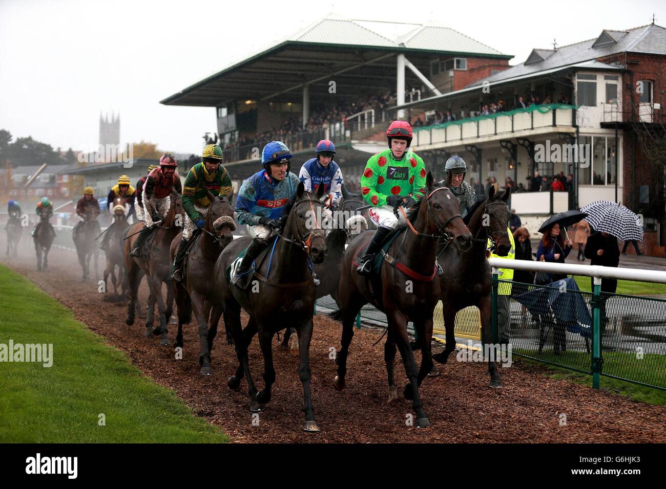 Läufer und Reiter kommen nach der Folge uns auf Twitter @WarwickRaces Handicap-Hürde auf der Warwick Racecourse, Warwickshire. Stockfoto