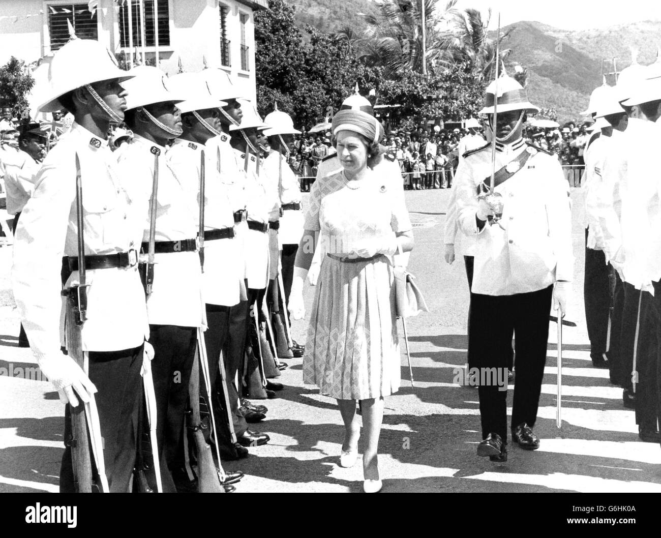 Die Königin, die vom Polizeichef R. K. Jones begleitet wurde, inspizierte am Mittwoch in Trotola eine Ehrenwache der Royal Virgin Islands Police, als sie und Prinz Philip die Britischen Jungferninseln im Rahmen der Silver Jubliee Tour durch Westindien besuchten. Stockfoto