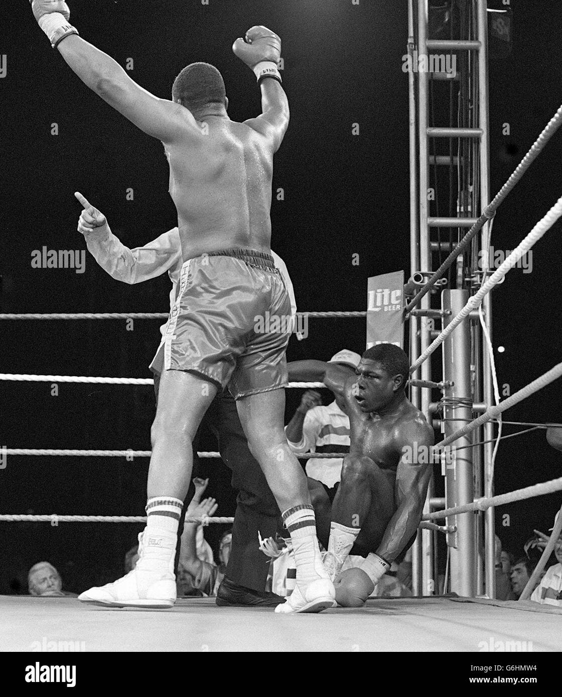 Frank Bruno versinkt in der Ecke auf seinen Geisterhacken, während der verdunkelte Schiedsrichter Insidro Rodriguez aus Venezuela den Weltmeister Tim Witherspoon wegstickt, bevor er den Titelkampf im Wembley Stadium beendet. Das Ende für Bruno kam in der 11. Runde des geplanten Jahres 15 und der Boxer Wandsworth ging zur Röntgenaufnahme seines Kiefers ins Krankenhaus. Stockfoto