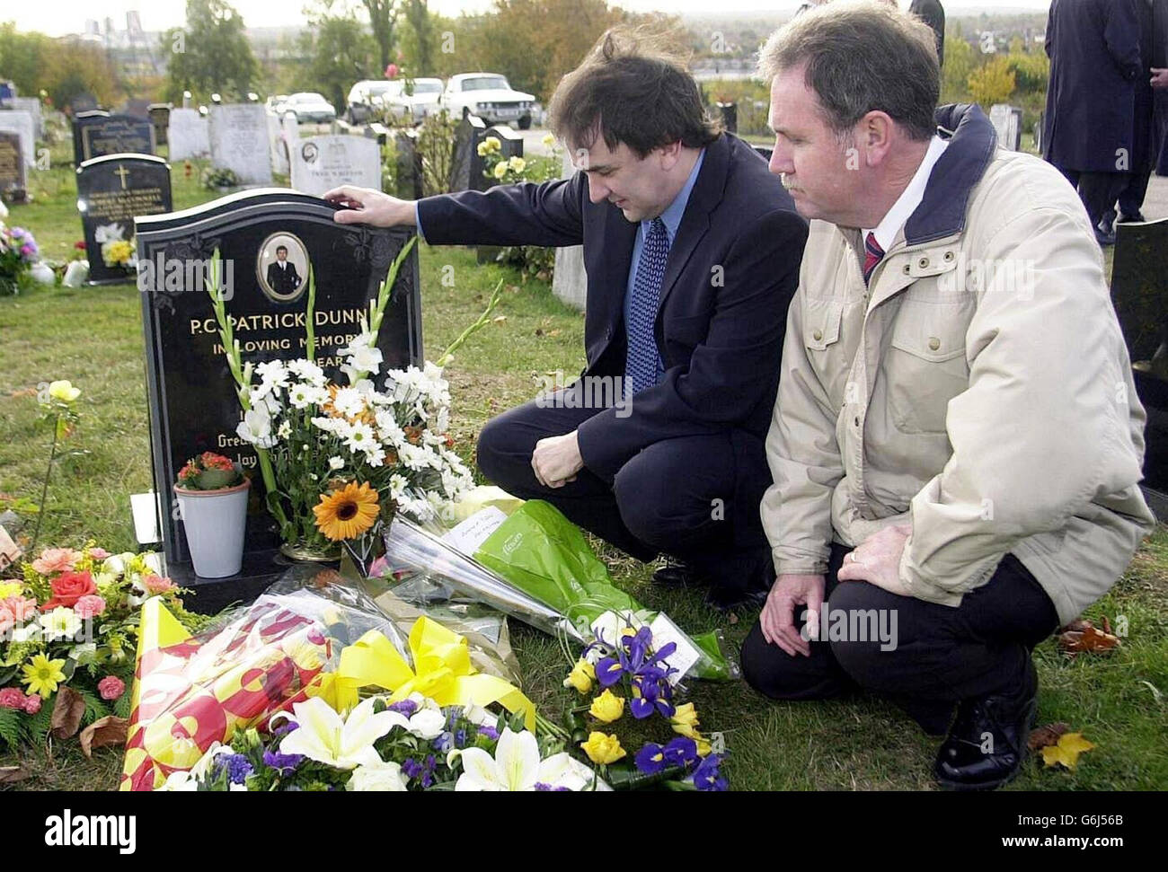 Ivan (links) und Stephen Dunne am Grab von PC Patrick Dunne, in Sutton Cemetry am 10. Todestag ihres Bruders. Der örtliche Clapham-Gemeindeoffizier PC Dunne wurde einmal in die Brust geschossen und bei der Ankunft im St. Thomas's Hospital vor 10 Jahren für tot erklärt. Stockfoto