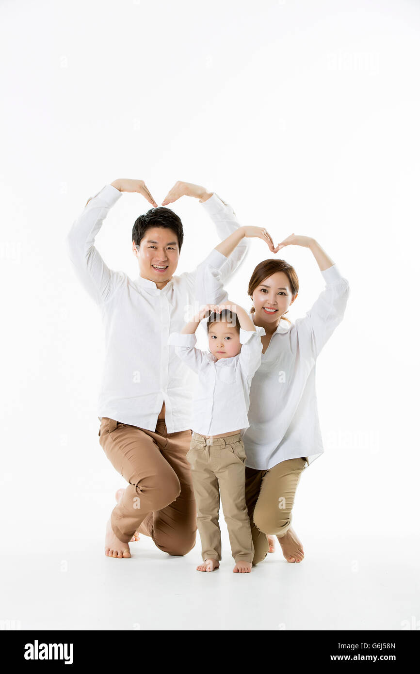 Glückliche asiatischen Familie posieren, so dass Herzschild mit Armen - Isolated on White Stockfoto
