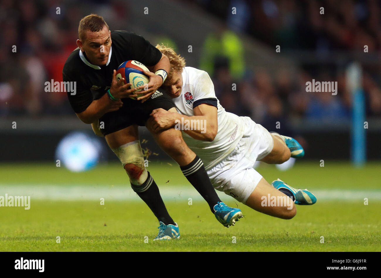 Rugby Union - QBE International - England / Neuseeland - Twickenham. Der Neuseeländer Aaron Cruden wird von Englands Billy Twelvetrees während der QBE International im Twickenham Stadium, London, angegangen. Stockfoto