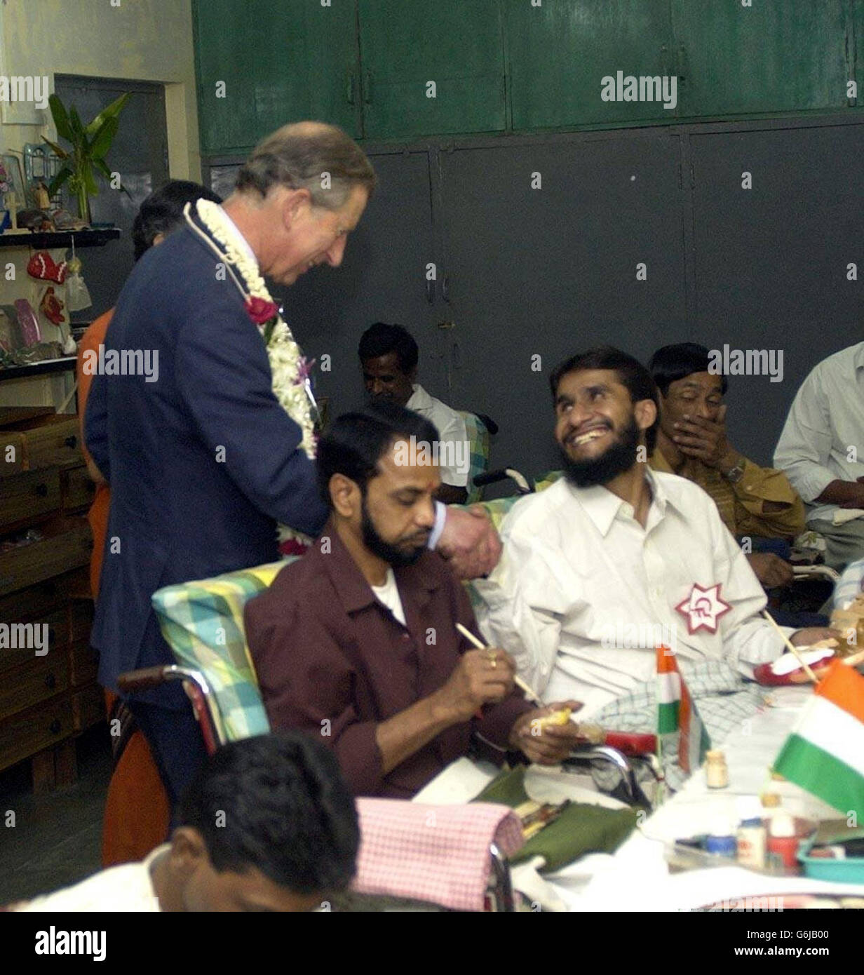 Prinz Charles schüttelt sich bei seinem Besuch in Mumbai, Indien, mit einem Mann in den Cheshire Homes for Disabled People die Hände. Stockfoto