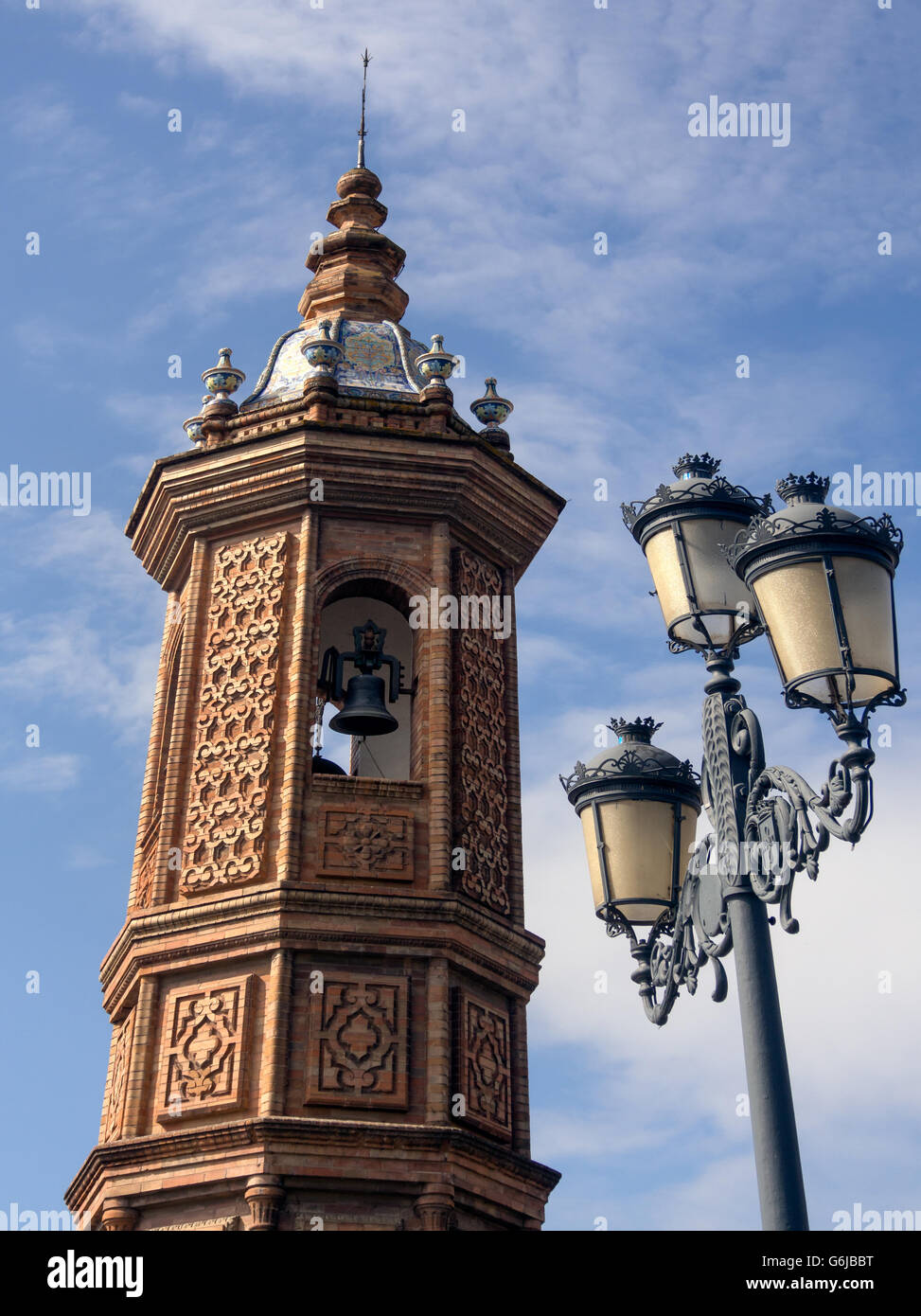 SEVILLA, SPANIEN - 15. MÄRZ 2016: Außenansicht des Glockenturms der maurischen Wiederbelebungskirche El Carmen und Vintage-Straßenlampe Stockfoto