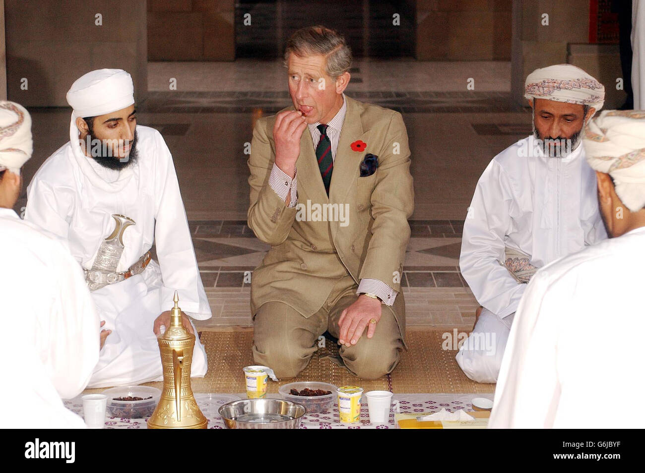 Der Prinz von Wales isst ein Datum, mit einer Gruppe von omanischen Muslimen, die Iftar (Fastenbruch, nach Sonnenuntergang) während des heiligen Monats Ramadan in der Sultan-Qaboos-Moschee einnehmen. Der Prinz besuchte die riesige Moschee am Rande des Maskats, der Hauptstadt von Oman, und wird morgen Nachmittag nach Großbritannien zurückfliegen. Stockfoto