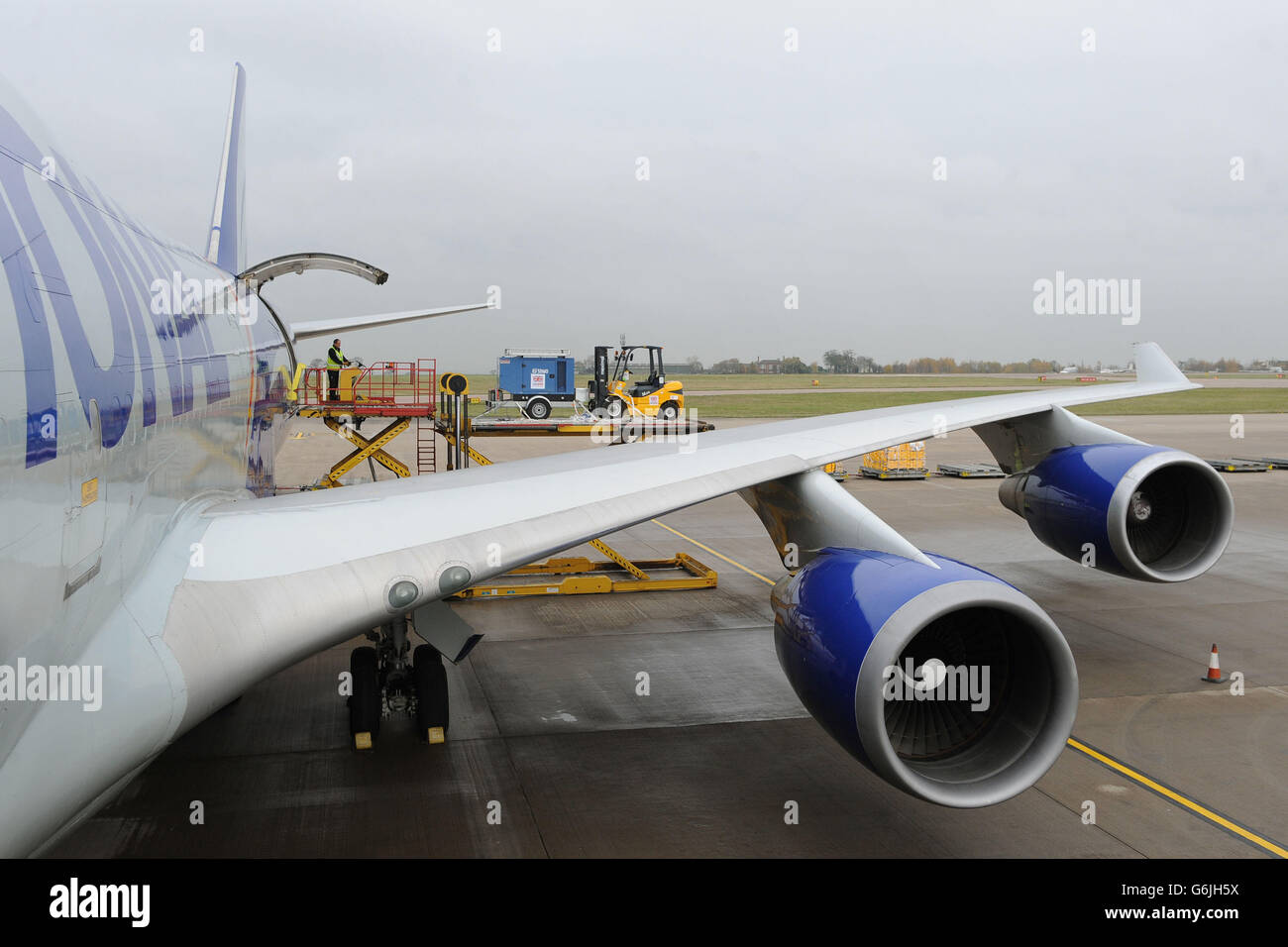 Bodenpersonal verladen Ausrüstung auf eine Boeing 747 am East Midlands Airport, die nach Cebu auf den Philippinen auffliegt, um die Hilfsmaßnahmen nach den Verwüstungen des Taifuns Haiyan zu unterstützen. Stockfoto