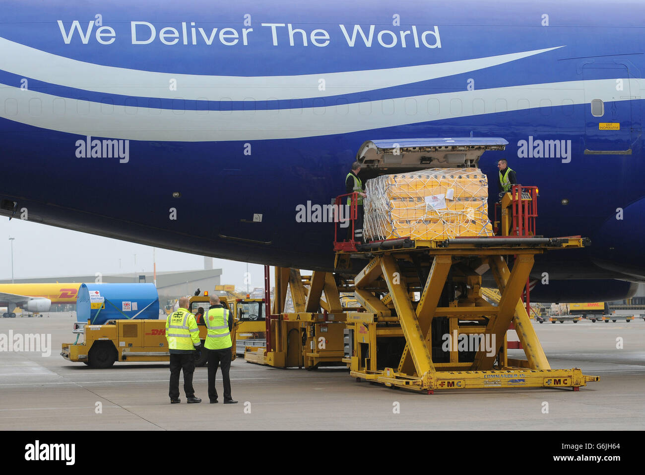 Bodenpersonal verladen Ausrüstung auf eine Boeing 747 am East Midlands Airport, die nach Cebu auf den Philippinen auffliegt, um die Hilfsmaßnahmen nach den Verwüstungen des Taifuns Haiyan zu unterstützen. Stockfoto
