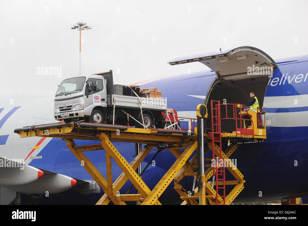 Bodenpersonal verladen Ausrüstung auf eine Boeing 747 am East Midlands Airport, die nach Cebu auf den Philippinen auffliegt, um die Hilfsmaßnahmen nach den Verwüstungen des Taifuns Haiyan zu unterstützen. Stockfoto