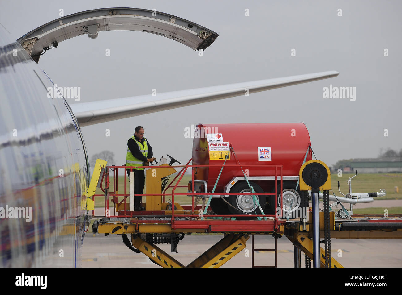 Bodenpersonal verladen Ausrüstung auf eine Boeing 747 am East Midlands Airport, die nach Cebu auf den Philippinen auffliegt, um die Hilfsmaßnahmen nach den Verwüstungen des Taifuns Haiyan zu unterstützen. Stockfoto