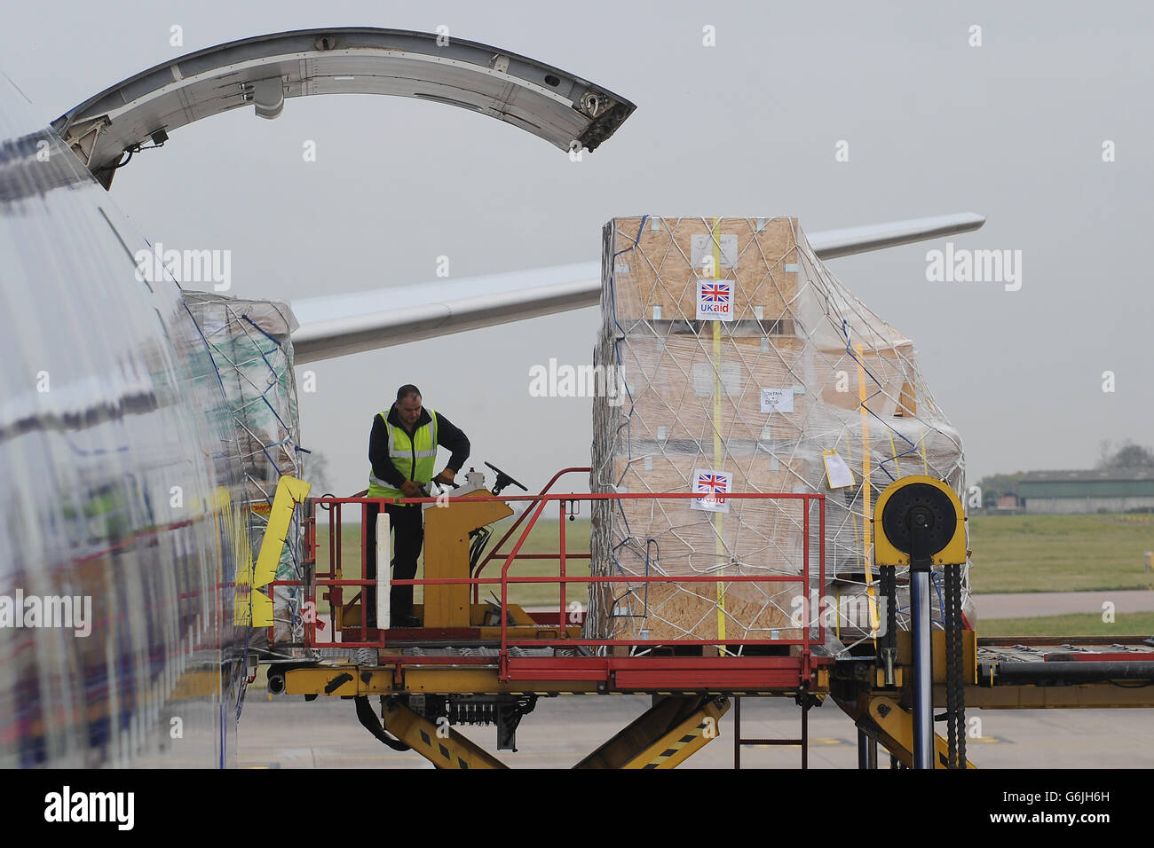 Bodenpersonal verladen Ausrüstung auf eine Boeing 747 am East Midlands Airport, die nach Cebu auf den Philippinen auffliegt, um die Hilfsmaßnahmen nach den Verwüstungen des Taifuns Haiyan zu unterstützen. Stockfoto