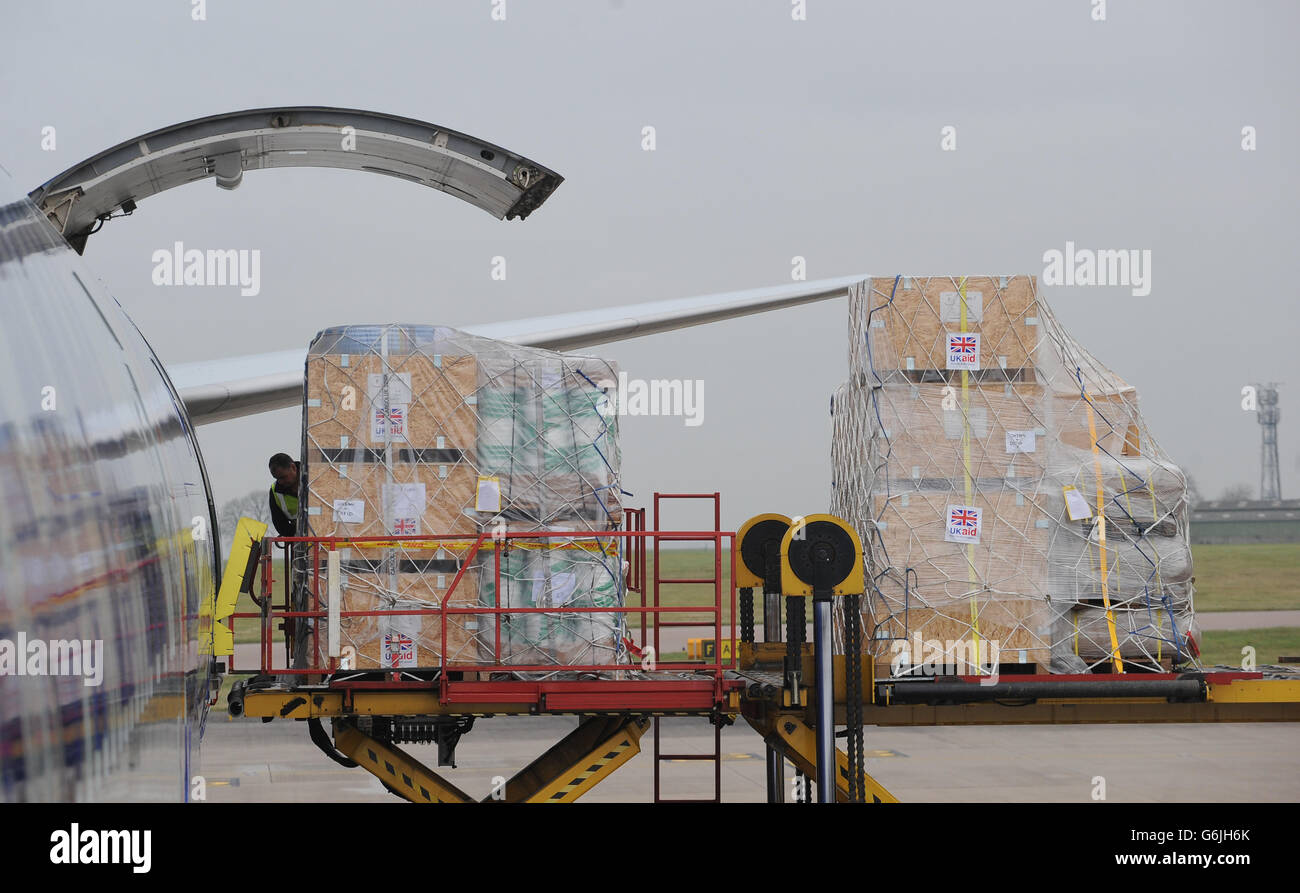 Bodenpersonal verladen Ausrüstung auf eine Boeing 747 am East Midlands Airport, die nach Cebu auf den Philippinen auffliegt, um die Hilfsmaßnahmen nach den Verwüstungen des Taifuns Haiyan zu unterstützen. Stockfoto