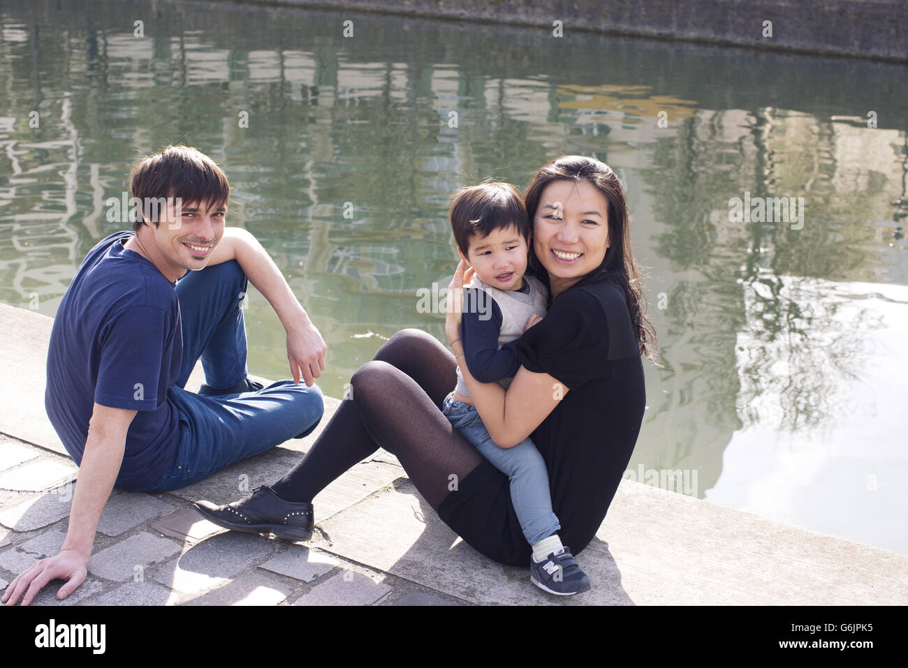 Eltern und Kind hängen am Ufer Stockfoto