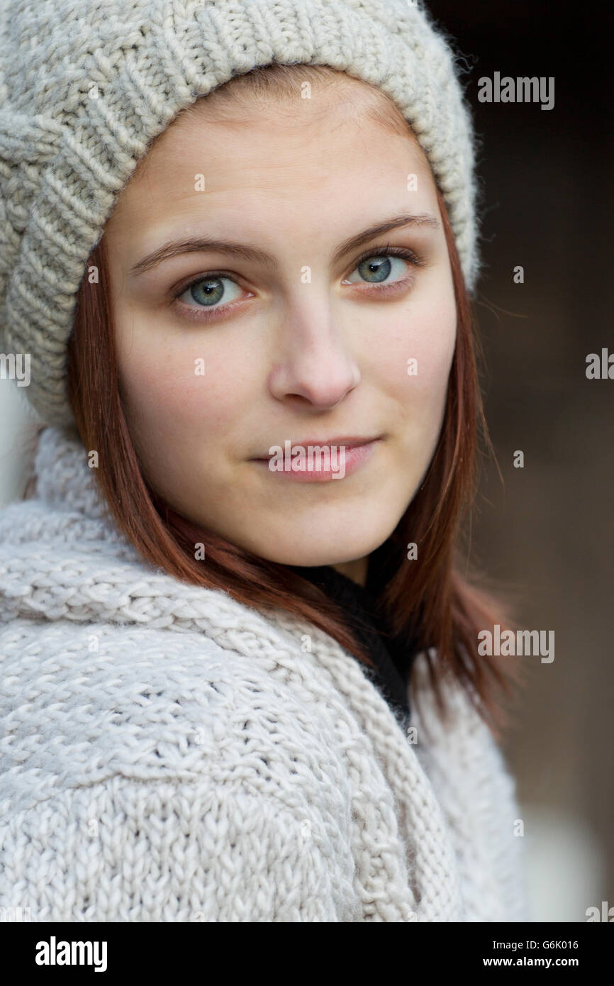 Junge Frau trägt eine Strickjacke und eine Wollmütze Stockfoto