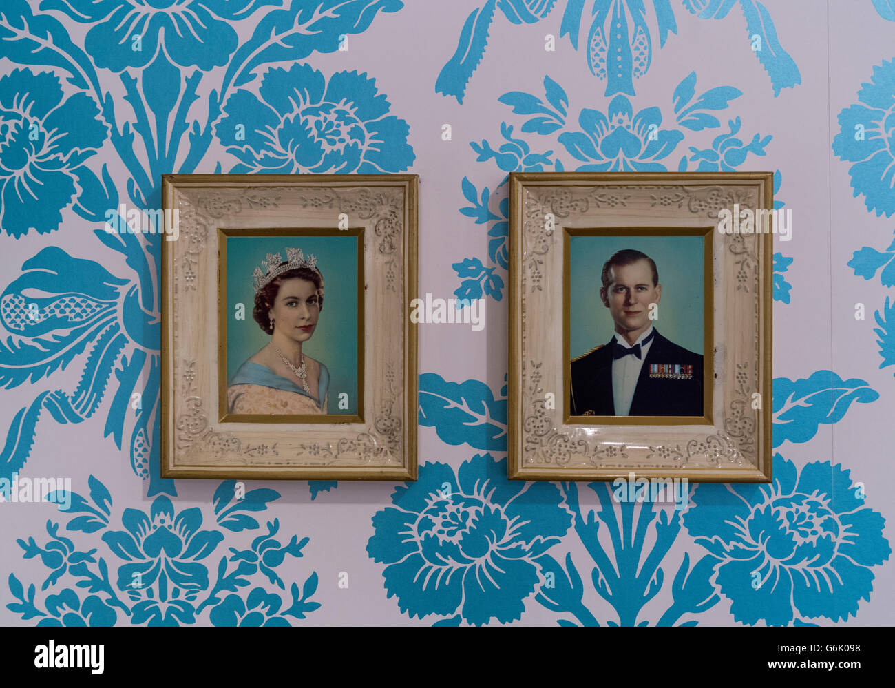 Bilder von Queen Elizabeth II und Prinz Philip auf Wand mit floral Tapete, Stuttgart Stockfoto