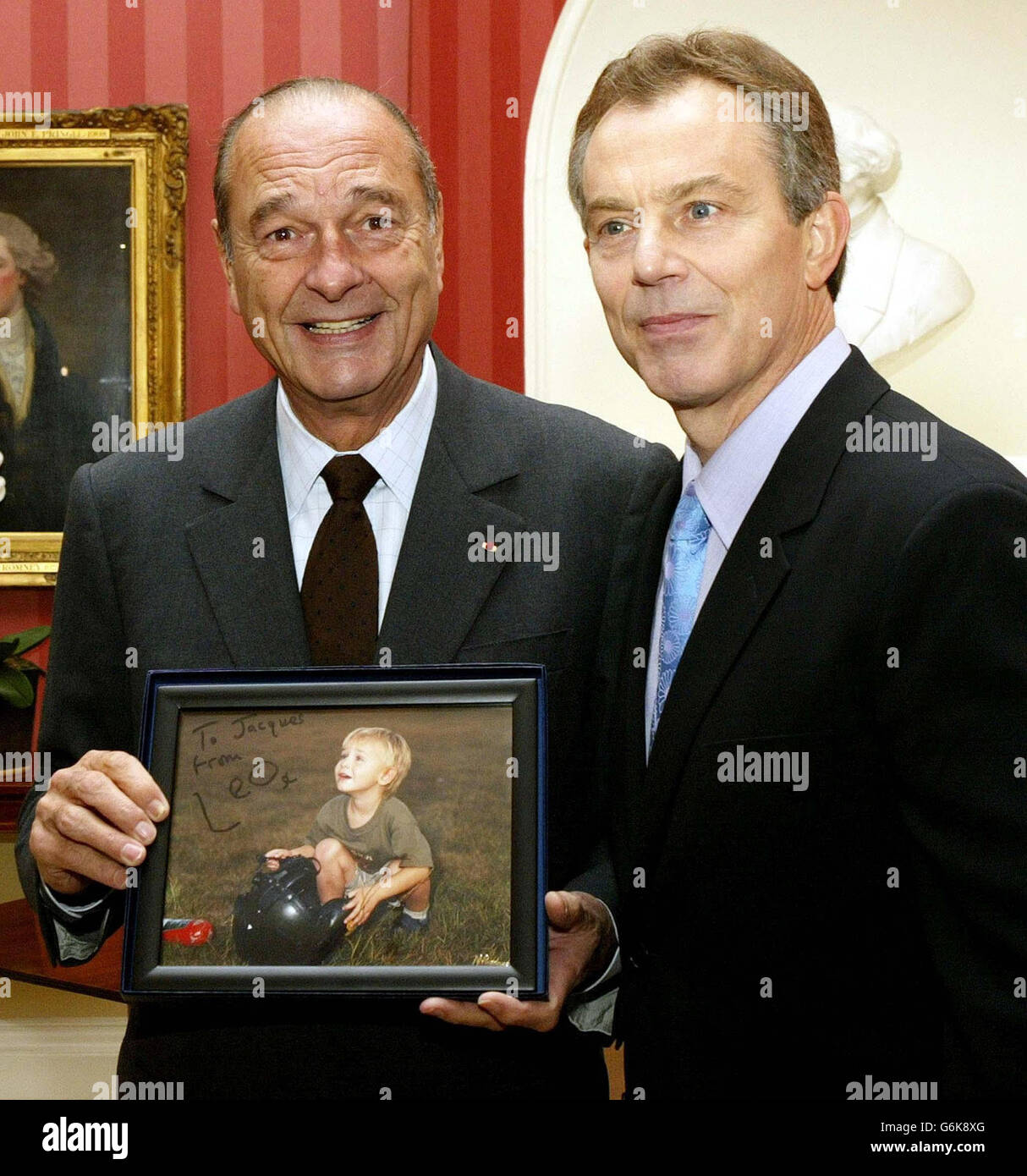 Der französische Präsident Jacques Chirac hält in der Downing Street im Zentrum von London ein Foto von Leo Blair, das der britische Premierminister Tony Blair präsentiert hat. Blair war Gastgeber des jüngsten englisch-französischen Gipfels, an dem Präsident Jacques Chirac und Premierminister Jean-Pierre Raffarin nur wenige Tage nach dem Staatsbesuch von Präsident Bush in Großbritannien teilnahmen. Er führte dann Gespräche mit dem spanischen Premierminister Jose Maria Aznar. Stockfoto