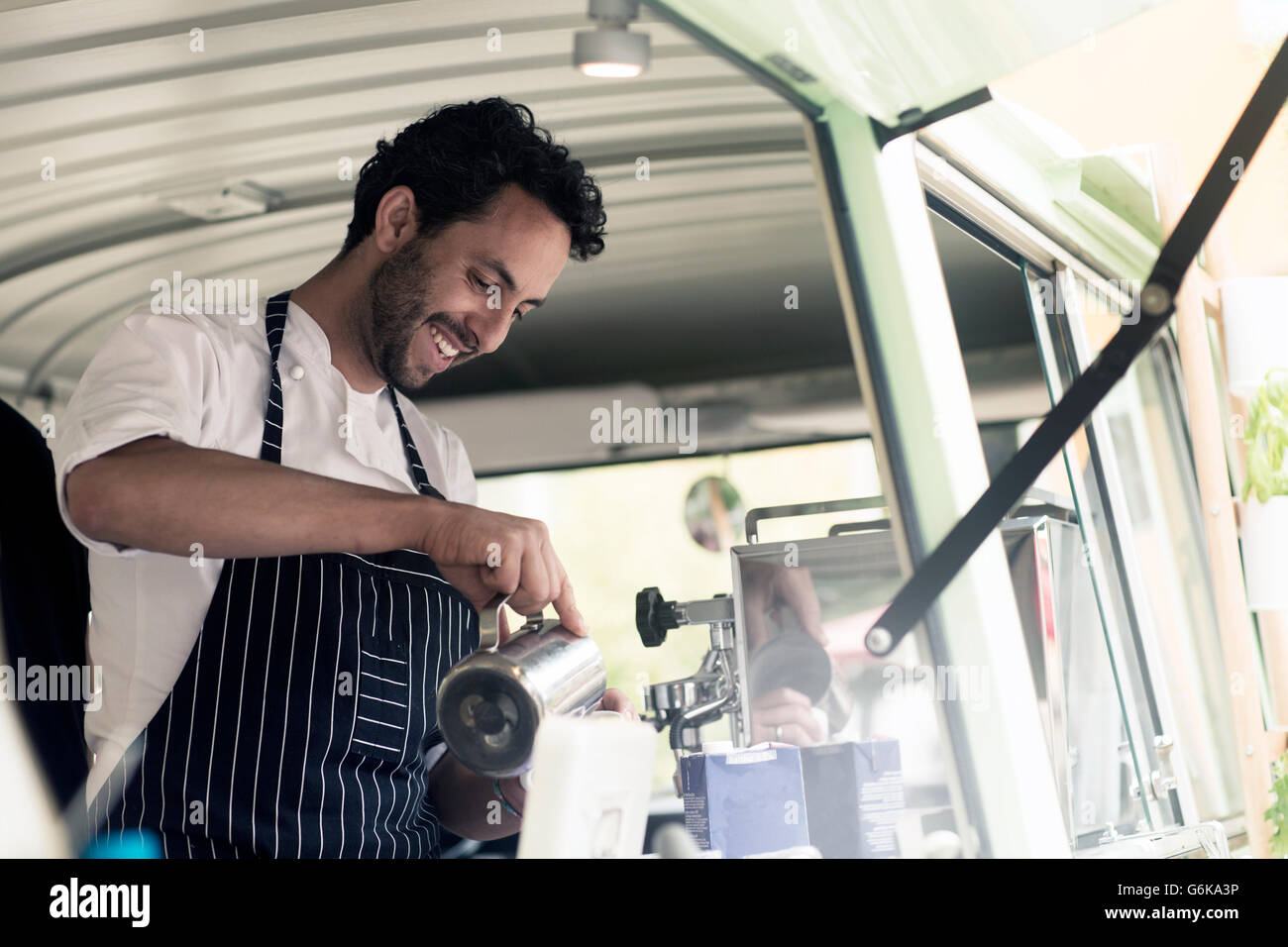 Lächelnder Mann arbeitet in einem Food truck Stockfoto