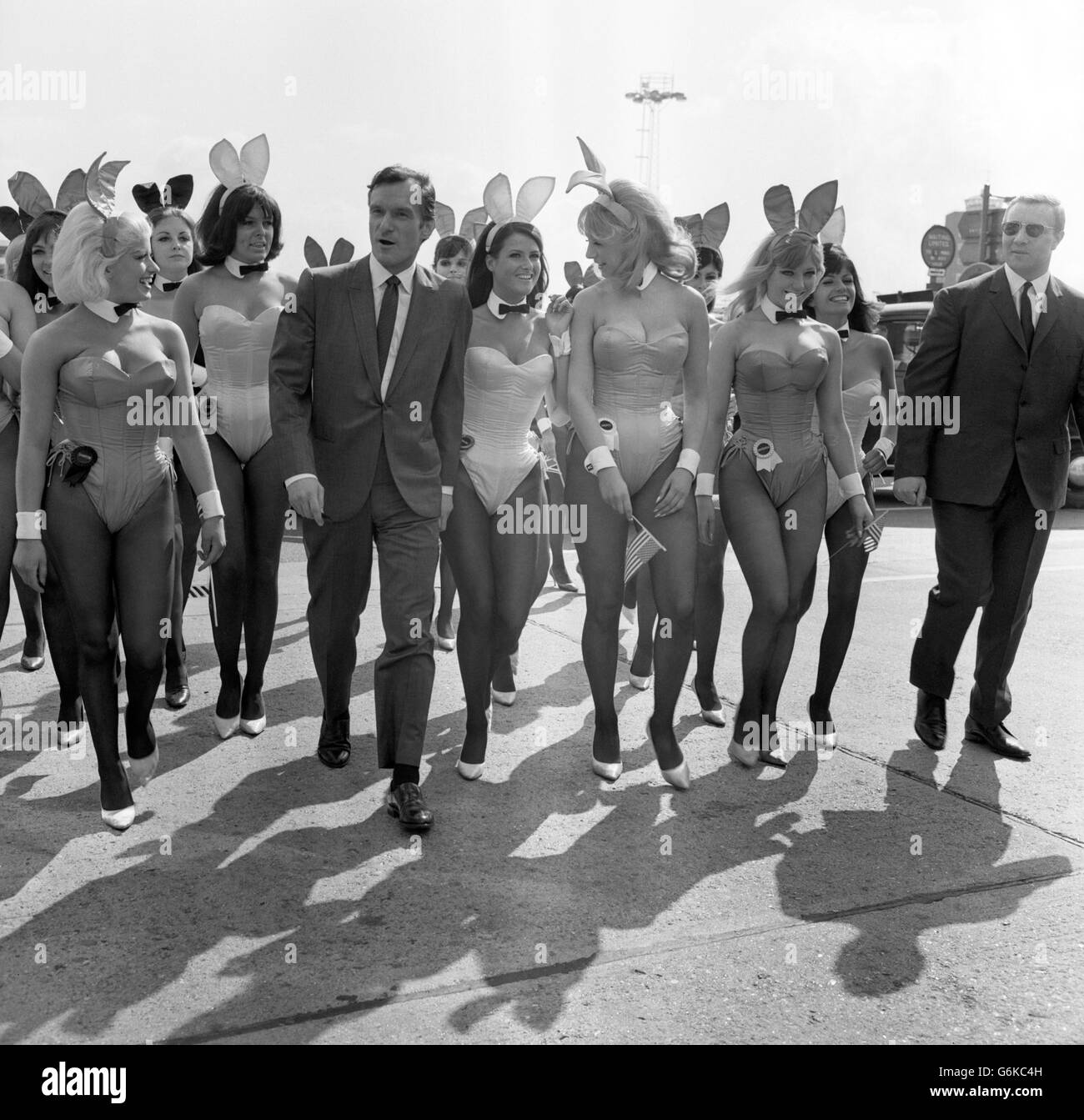 Hugh Hefner, der Chef des Playboy, der von einigen seiner Hasen empfangen wurde, als er aus Amerika am Flughafen London ankam. Hefner, der 40-jährige Herausgeber des Playboy Magazine und Präsident von Playboy Club International, ist hier, um an der Eröffnung seines ersten Playboy Clubs in Europa in der Londoner Park Lane teilzunehmen. Fünfzig der hundert Playboy Club Bunnies in Kostüm begrüßten ihn am Flughafen. Stockfoto