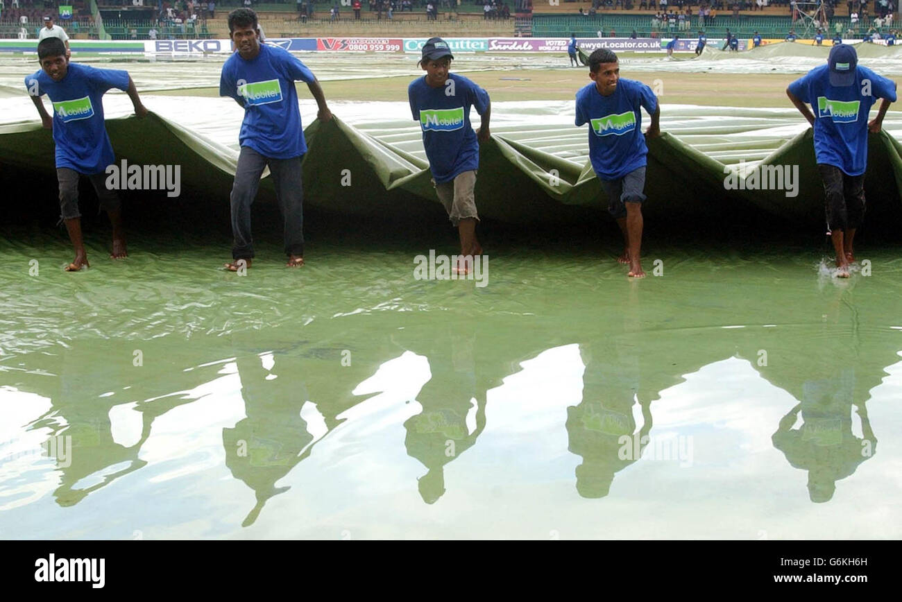 Die Bodenmitarbeiter kämpfen gegen ein vom Wasser abgeholztes Außenfeld, da schwere Stürme im Premadasa-Stadion in Colombo das dritte Tag/Nacht-Spiel der eintägigen internationalen Serie zwischen England und Sri Lanka stören. Stockfoto