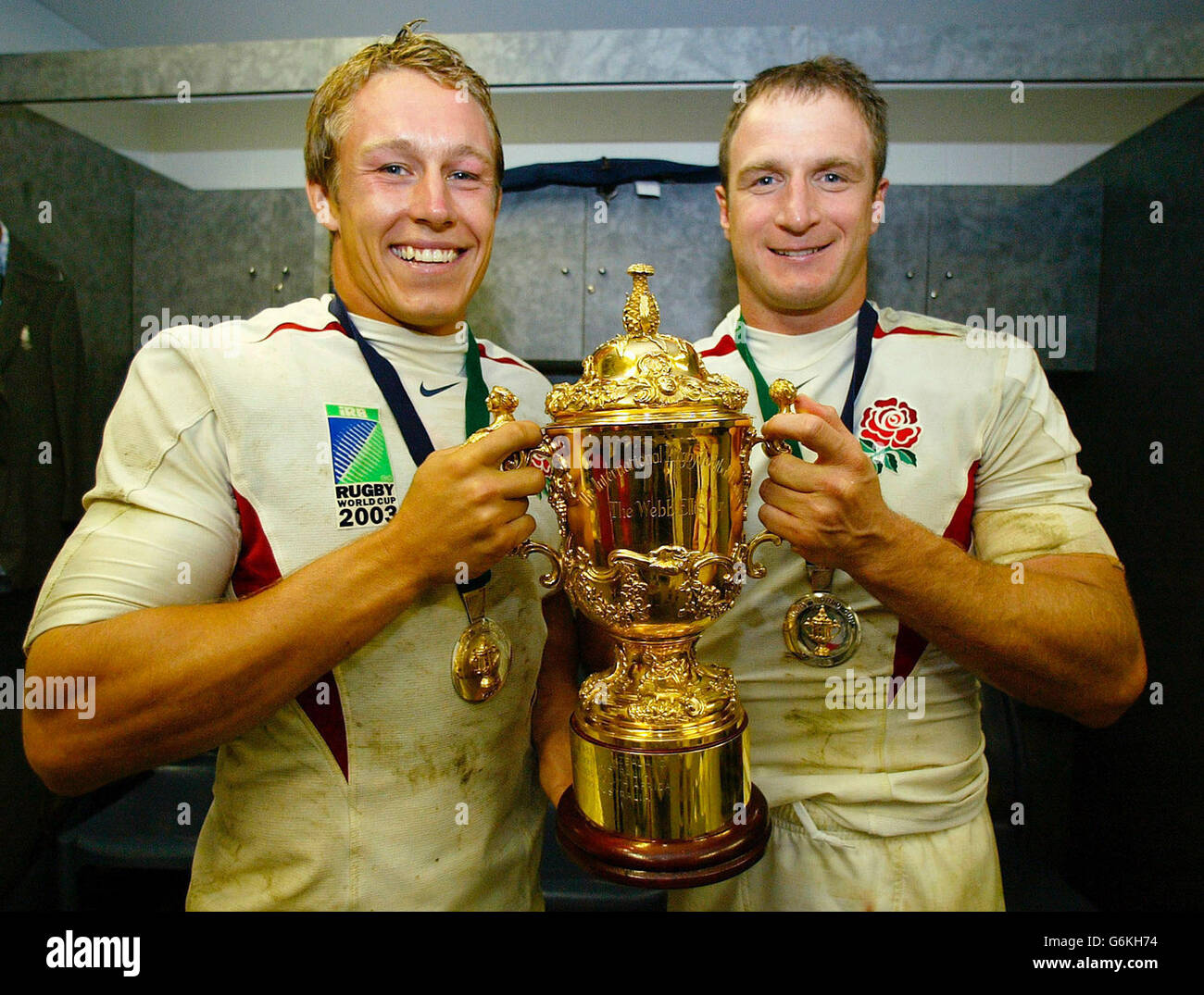 Jonny Wilkinson ging und Mike Catt aus England feiert in den Umkleideräumen mit der William Webb Ellis Trophäe nach dem Sieg Englands bei der Rugby-Weltmeisterschaft gegen Australien in Sydney. Stockfoto