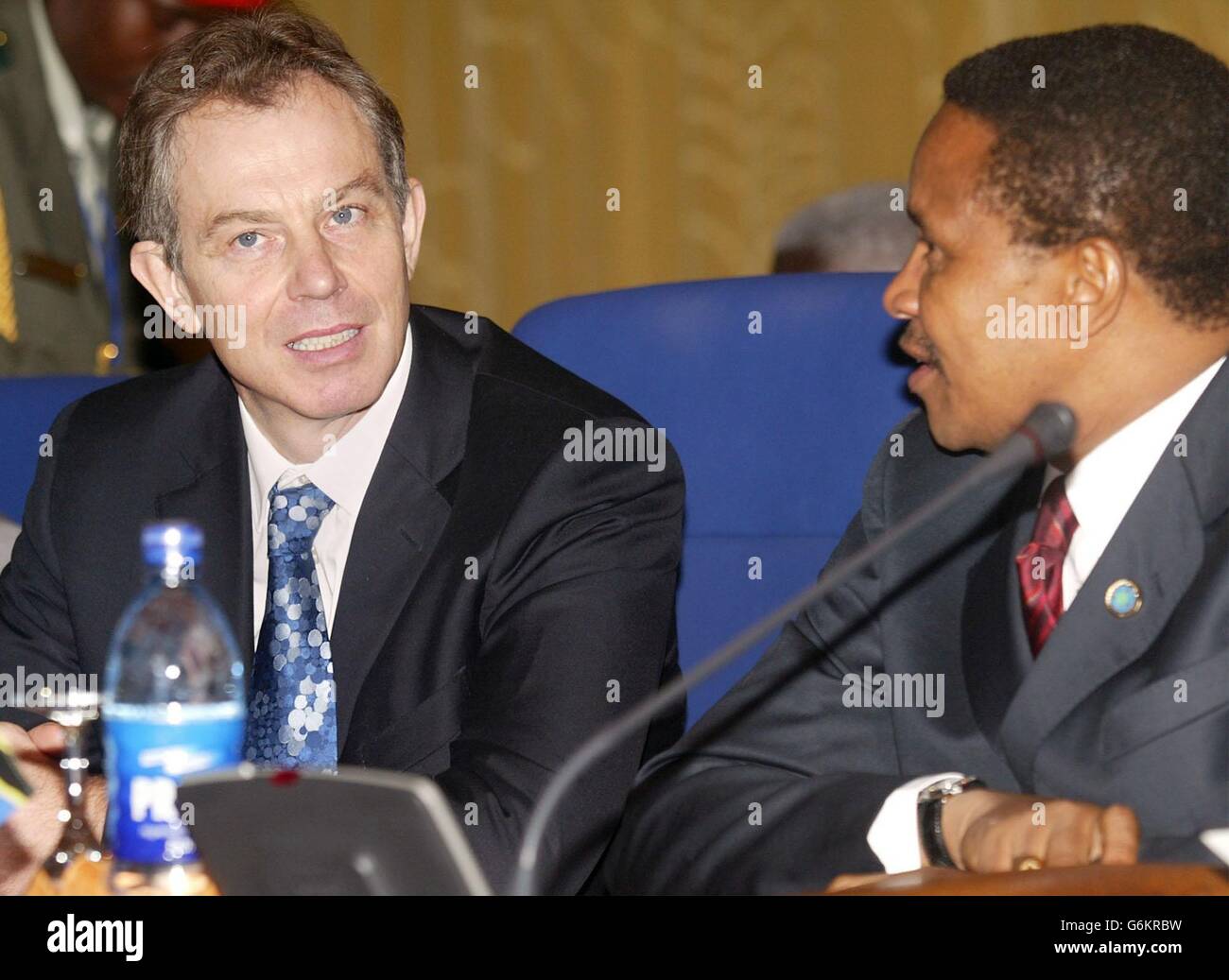 Der britische Premierminister Tony Blair (L) spricht mit dem tansanischen Präsidenten Benjamin William Mkapa zu Beginn der ersten Exekutivsitzung des Commonwealth-Treffens der Regierungschefs in Abuja, Nigeria. Blair hat heute nicht die rasche Entschließung erhalten, die er wollte, dass Simbabwe die Aussetzung aus dem Commonwealth fortsetzt. Er hatte gehofft, dass sich die in Nigeria versammelten Führer darauf einigen würden, die Sanktionen gegen das Zanu-PF-Regime von Robert Mugabe bei der Eröffnungssitzung des Gipfels beizubehalten. Stockfoto