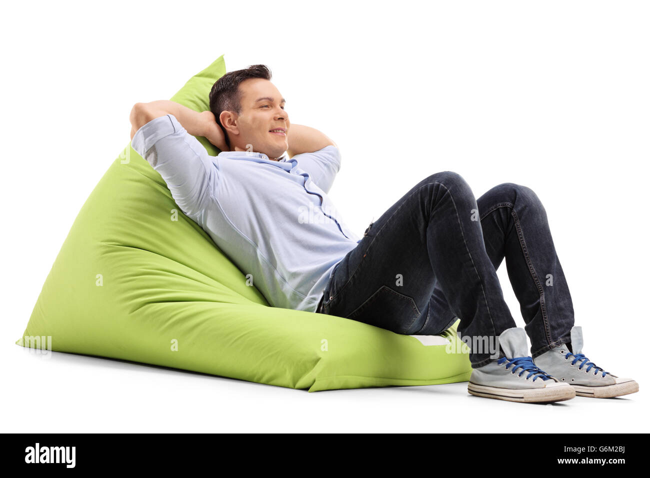 Entspannte junger Kerl Verlegung auf eine angenehm grüne Sitzsack isoliert auf weißem Hintergrund Stockfoto