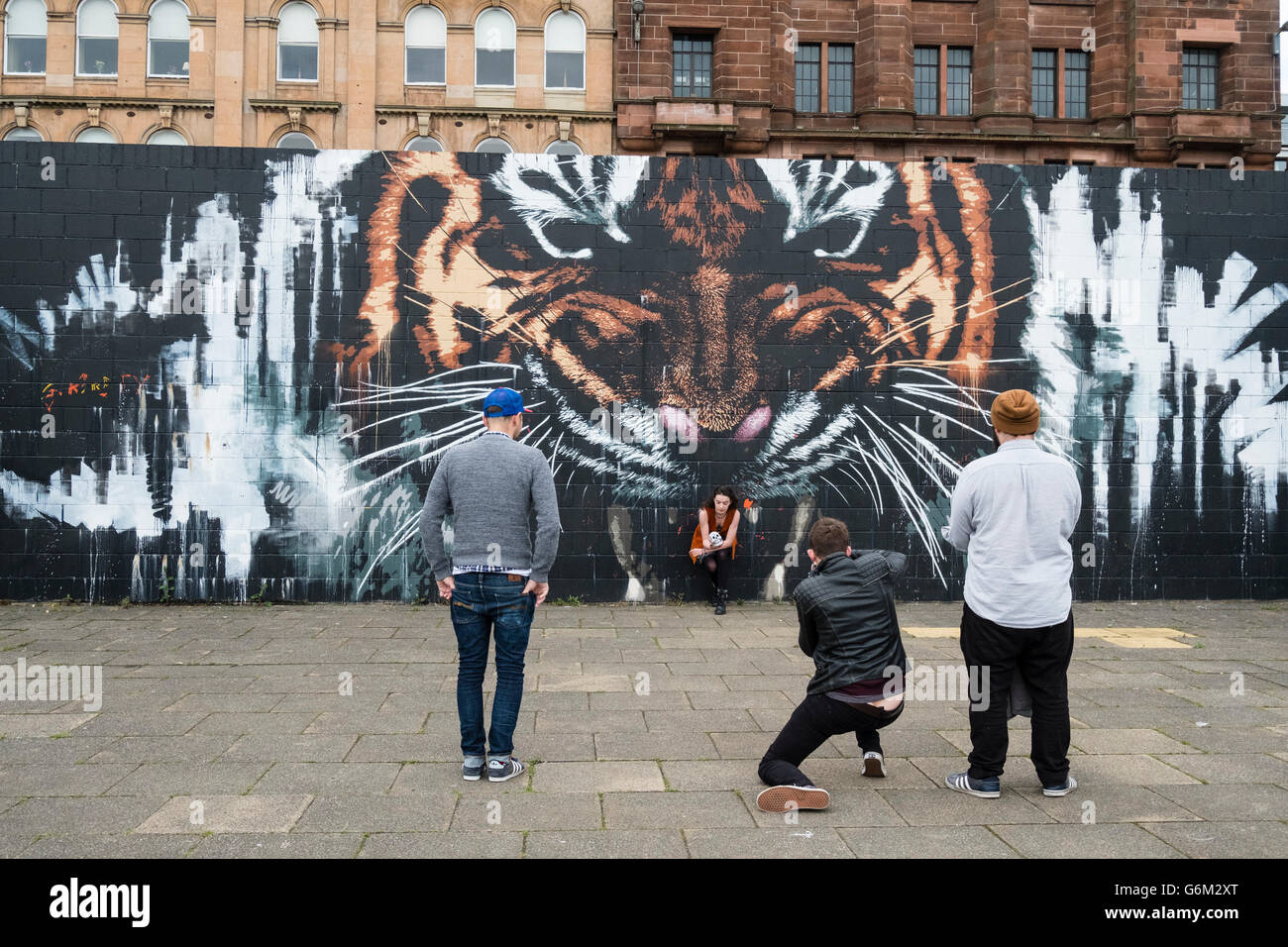 Straßenszene mit Tiger Fototapete, street Art auf Gehweg neben River Clyde in zentralen Glasgow, Schottland, Vereinigtes Königreich Stockfoto