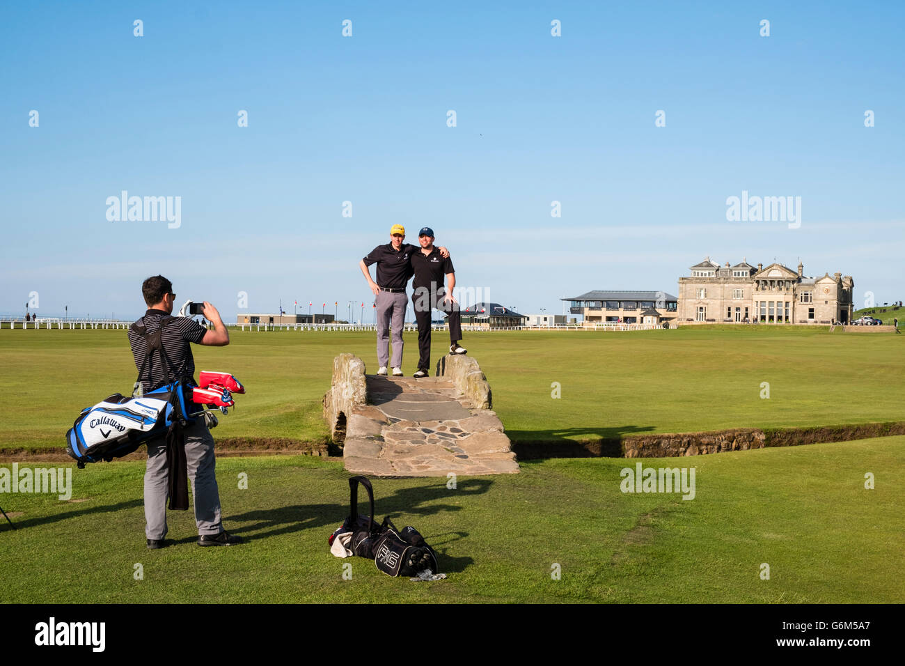 Golfer, posiert für Fotos auf Swilken Burn Brücke am Fairway des 18. Loch am Old Course in St. Andrews in Fife, Schottland Stockfoto