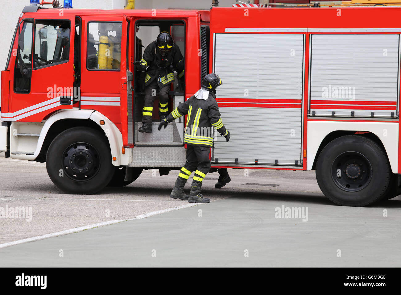 Feuerwehrauto vor dem brennenden Gebäude hochgezogen. Stockfoto