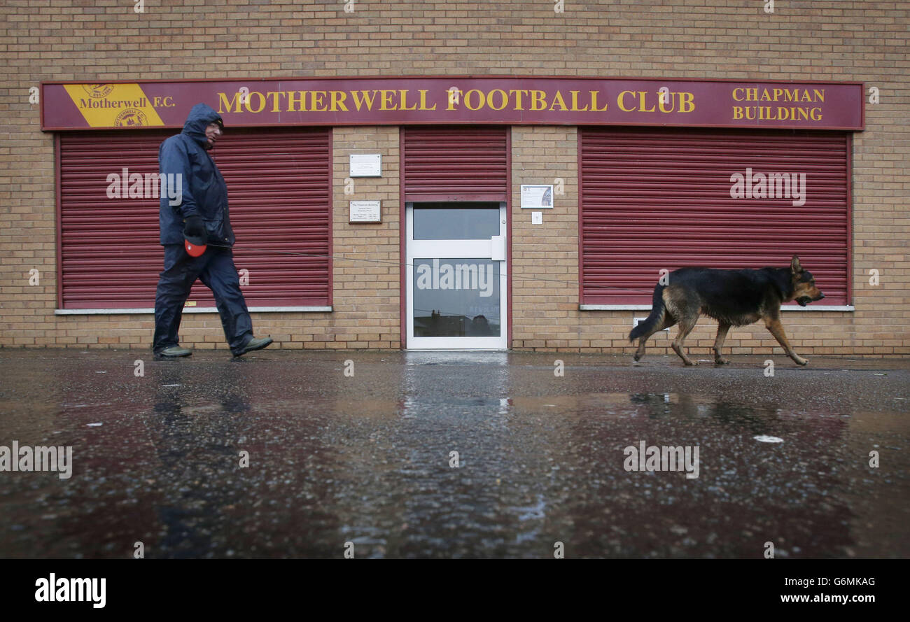 Ein Mann geht mit seinem Hund an Fir Park vorbei, nachdem Motherwells schottisches Premiership-Spiel mit Inverness wegen eines wasserbewaldeten Platzes verschoben wurde. Stockfoto