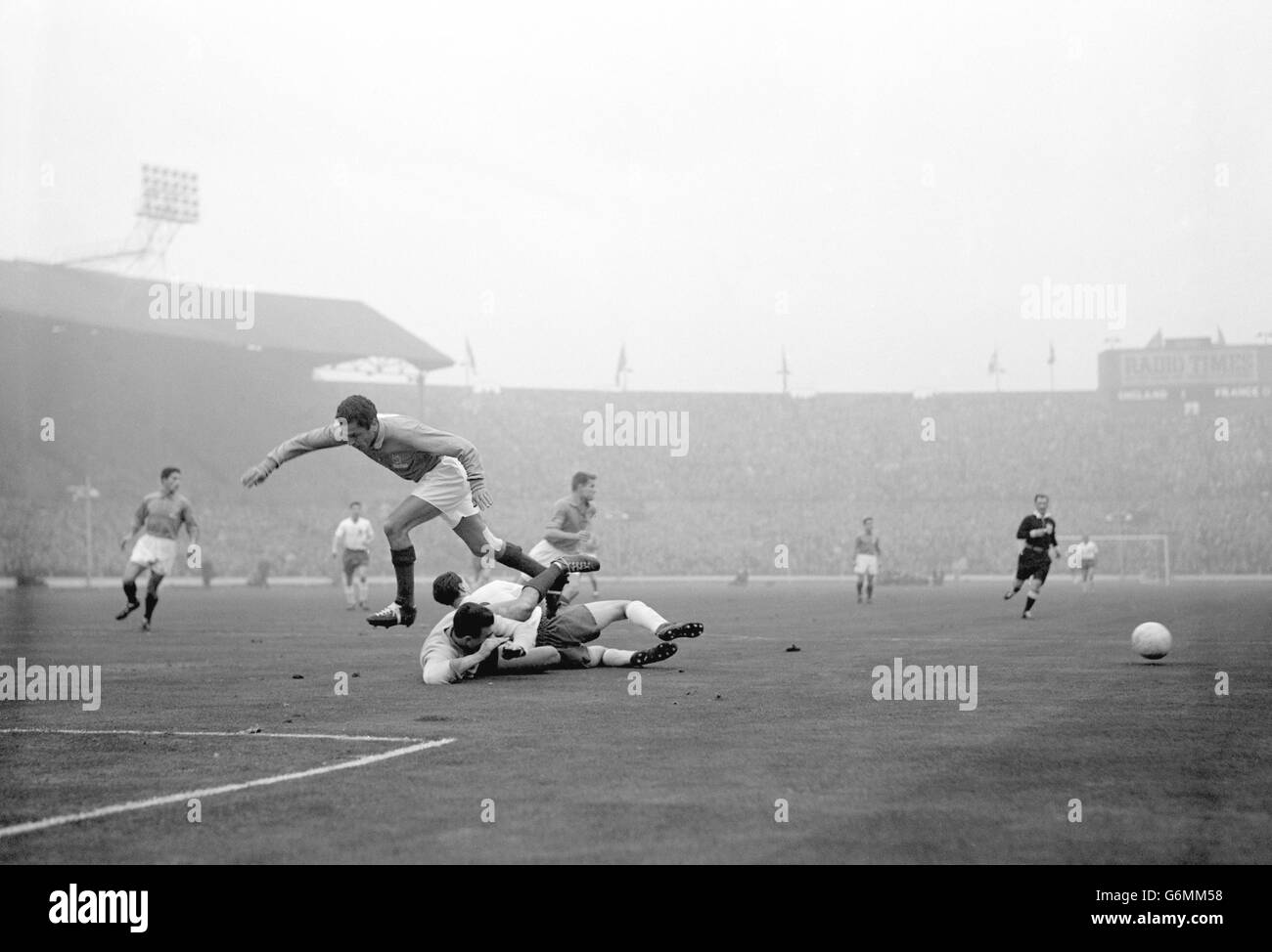 Frankreichs Torhüter Claude Abbes geht mit dem Engländerin Bobby Robson in die Höhe, während Frankreichs Mustapha Zitouni bei einem England-Angriff auf das französische Tor in Wembley über die Spitze springt. Mustapha Zitouni würde 1958 vor dem WM-Finale Frankreich verlassen, um für seine Heimat Algerien zu spielen. Stockfoto