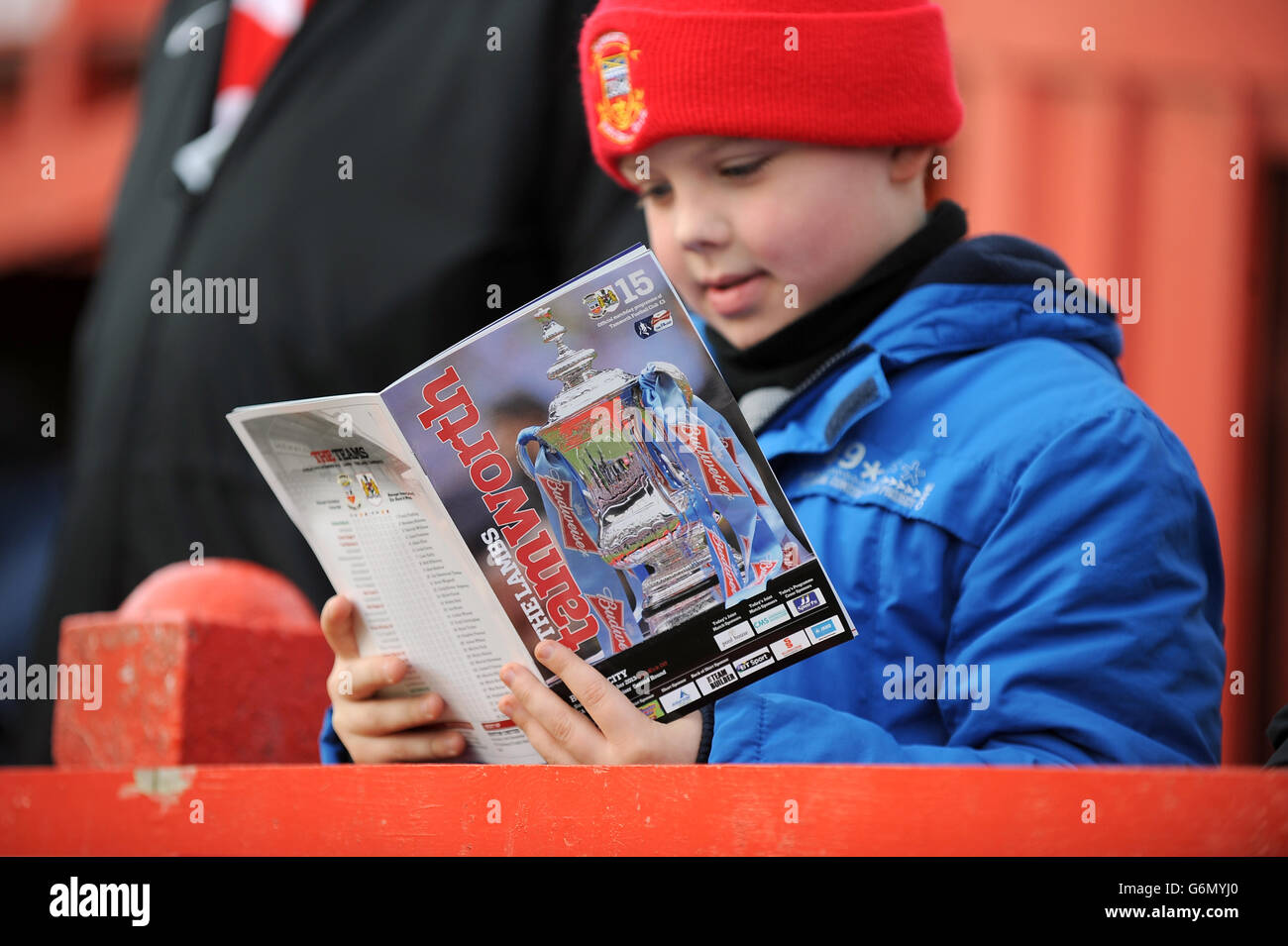 Fußball - FA Cup - zweite Runde - Tamworth gegen Bristol City - The Lamb Ground. Ein junger Fan liest das Spieltagsprogramm vor dem Spiel auf den Ständen Stockfoto