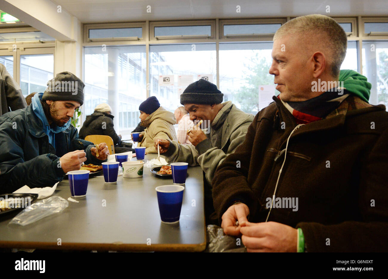 Obdachlose „Gäste“, die im Weihnachtszentrum in London in der Krise sind, frühstücken während sie während der Weihnachtszeit ankommen, während andere Obdachlosenheime während der Ferienwoche schließen. Stockfoto