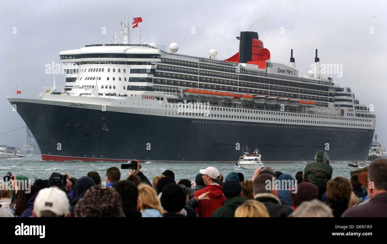 Die Zuschauer beobachten, wie der größte und teuerste Cunard-eigene Kreuzfahrtdampfer der Welt, die unter britischer Flagge gezeichnete Queen Mary 2, in seinem neuen Heimathafen Southampton eintrifft. Das 550-Millionen-Schiff soll am 8. Januar offiziell in Southampton von der Queen benannt werden, und vier Tage später wird das 150,000-Tonnen-Schiff auf seiner ausverkauften Jungfernreise nach Fort Lauderdale, Florida, abreisen. 12/04/2004: Das neue Luxusliner wird am Montag, den 12 2004. April, nach seiner zweiten transatlantischen Kreuzfahrt, vier Stunden Verspätung in Southampton haben. Das Schiff hatte ein Problem mit einer Tür über einem Bugstrahlruder - Stockfoto