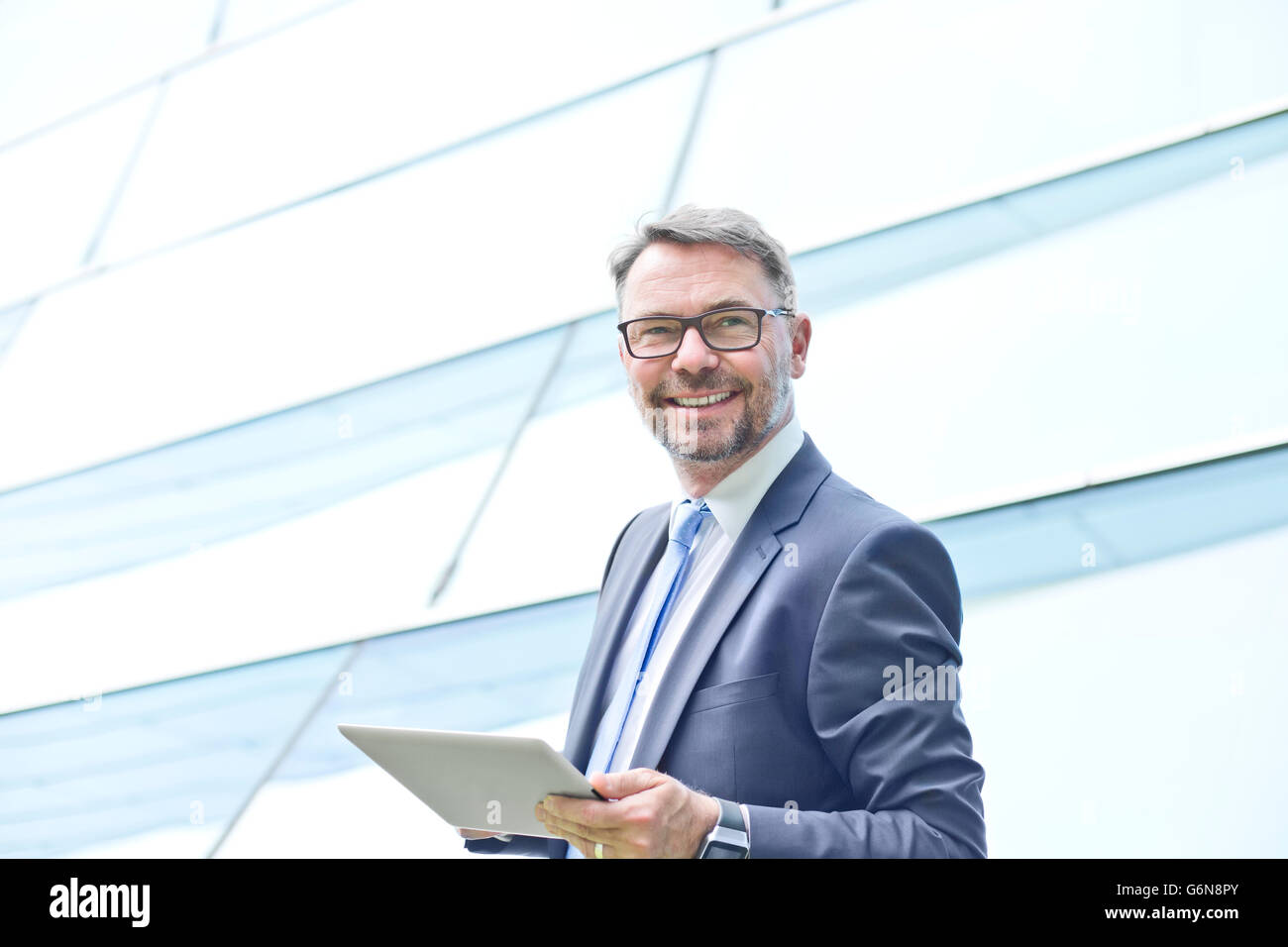 Lächelnde Geschäftsmann mit digitalen Tablet im freien Stockfoto
