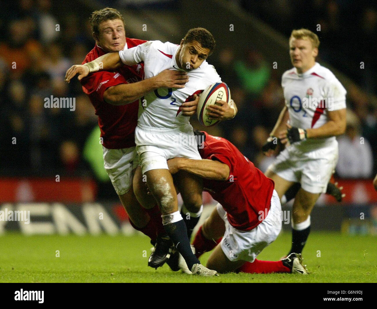 Der englische Jason Robinson wird von Tony Woodcock (links) und Keith Lowen (rechts) von den NZ Barbaren während des Spiels der Zürcher Weltmeister-Herausforderung in Twickenham, London, angegangen. Stockfoto