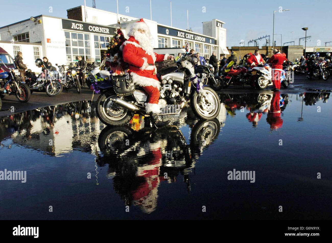 Ein Biker im Weihnachtsmann-Outfit begleitet über hundert Motorradfahrer im Ace Cafe, Brent, im Norden Londons, um Kindern Weihnachtsgeschenke im Central Middlesex Hospital, St. Mary's Hospital und St. Thomas' Hospital zu überreichen. Stockfoto