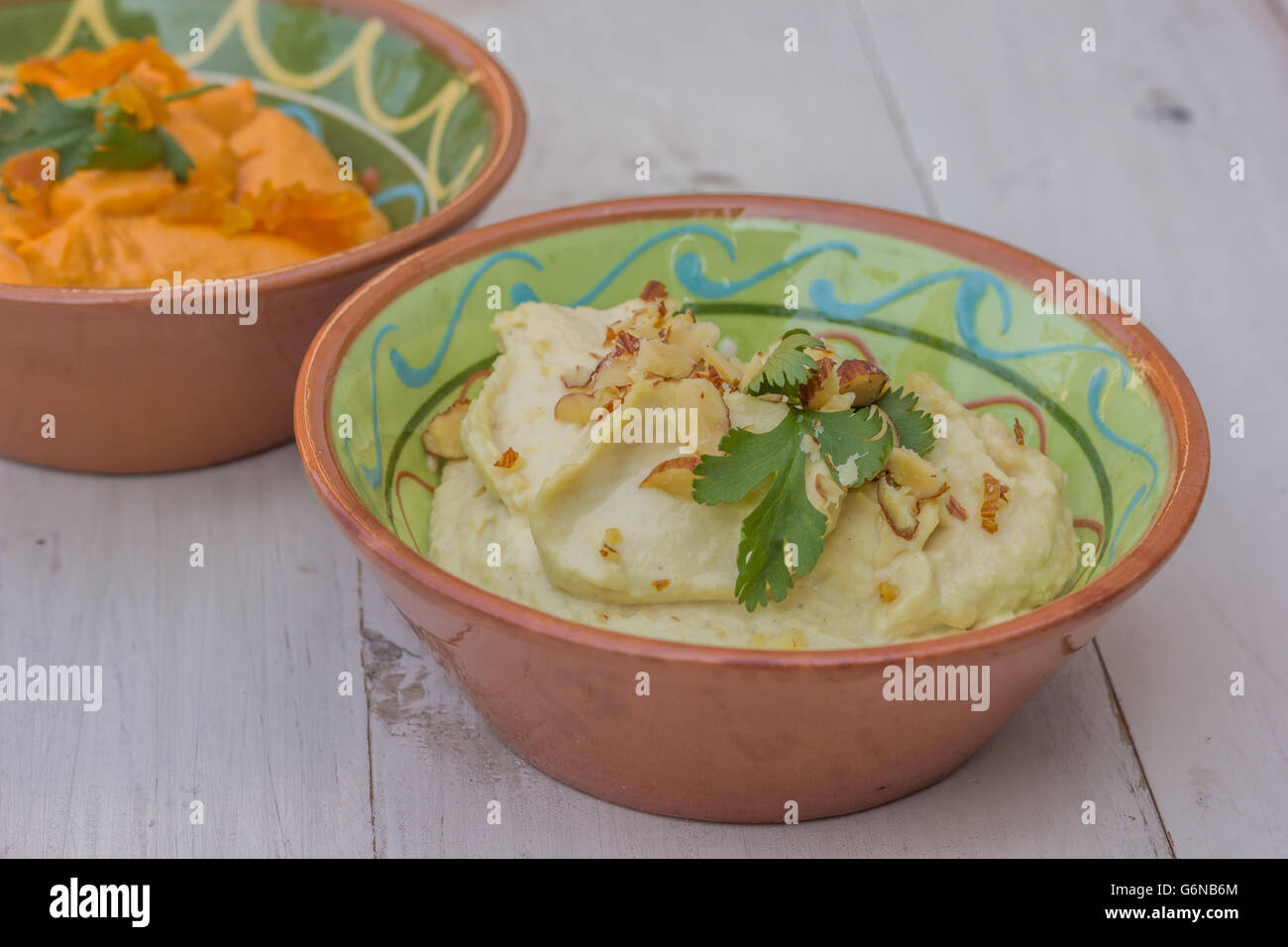 Weiße Humus auf einem weißen Holztisch Stockfoto