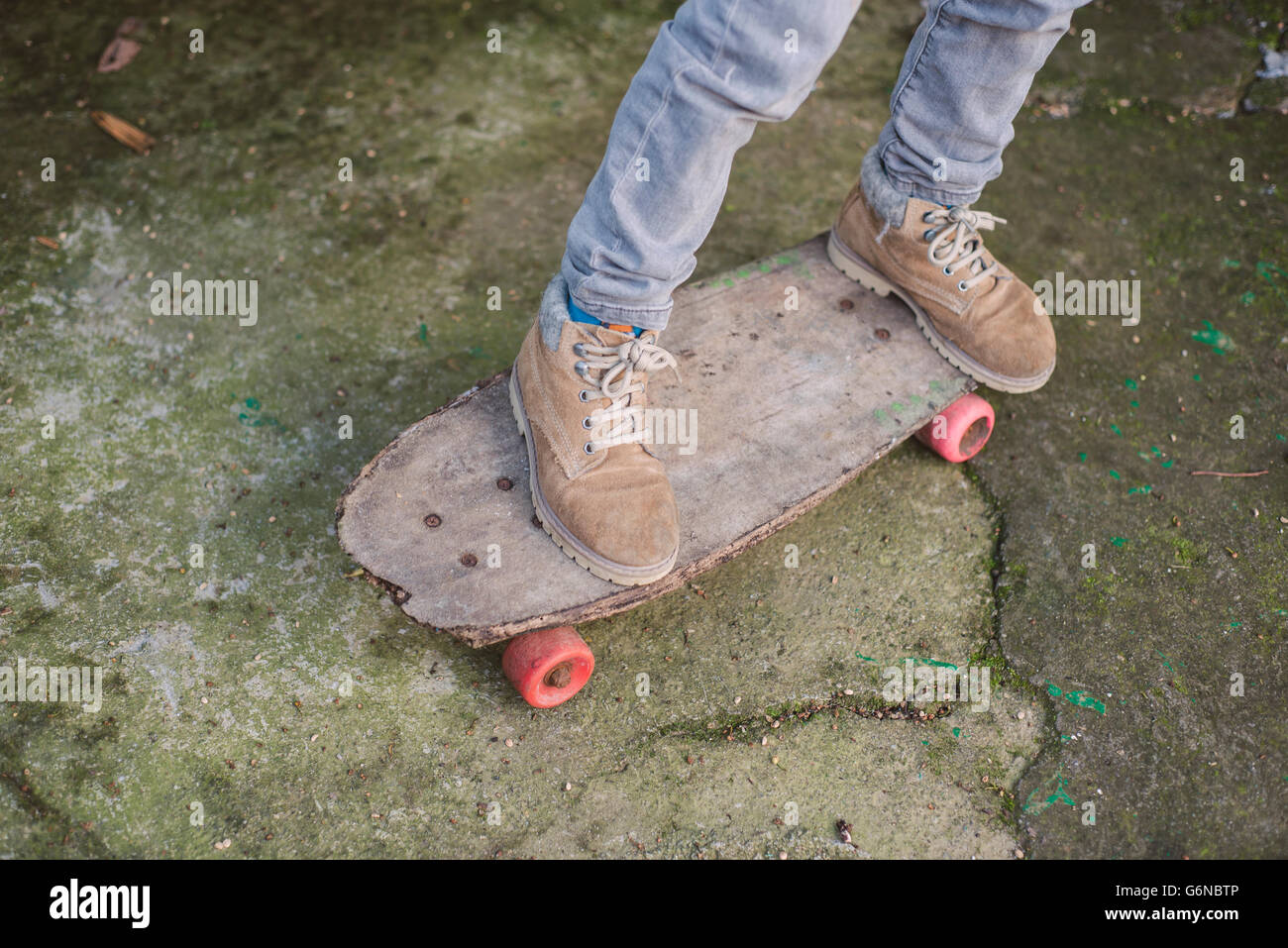 Beine des jungen auf einem alten skateboard Stockfoto