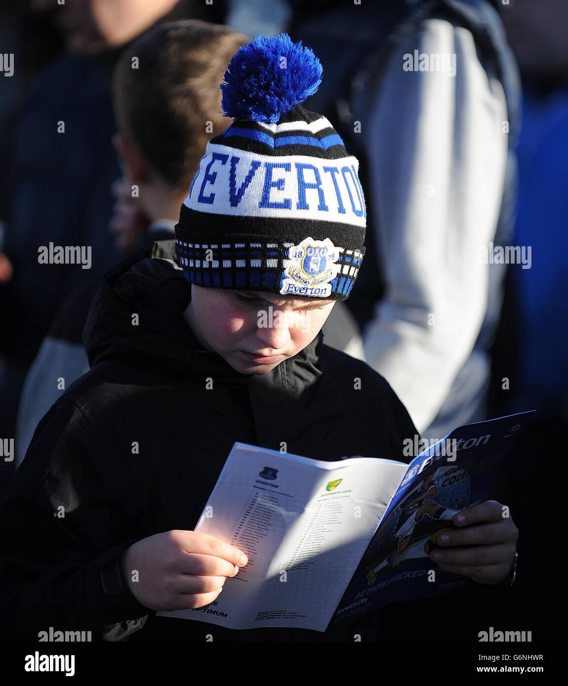 Ein junger Everton-Fan liest das Spieltagsprogramm in der Fanzone Stockfoto