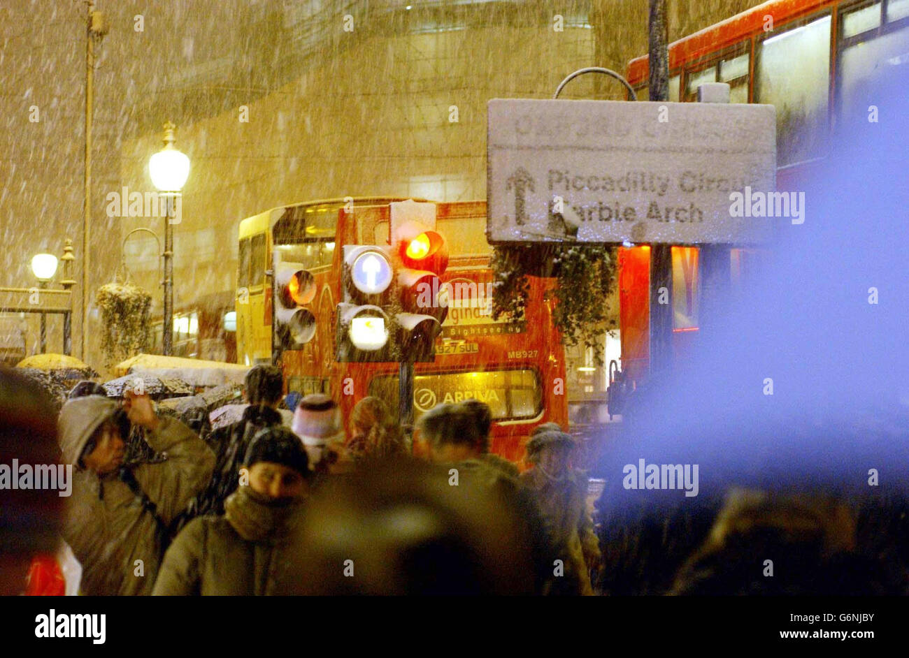 Shopper auf der Londoner Oxford Street werden in den Schneeschauern gefangen. Großbritannien war auf eine weitere Nacht mit Schnee, Eis und eisigen Temperaturen vorbereitet, als der Kälteeinbruch heute andauerte. Stockfoto