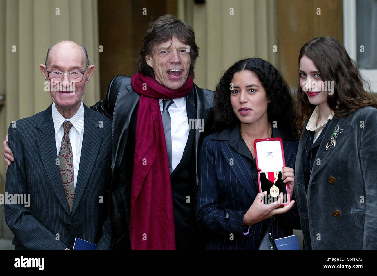 Rolling Stone Sir Mick Jagger, 60, mit seinem stolzen 92-jährigen Vater Joe und den Töchtern Elizabeth, 19, (rechts) und Karis, 32, Mit der Ritterschaft, die er für Verdienste um die populäre Musik erhielt, während einer Zeremonie, die der Prinz von Wales im Buckingham Palace hielt. Stockfoto