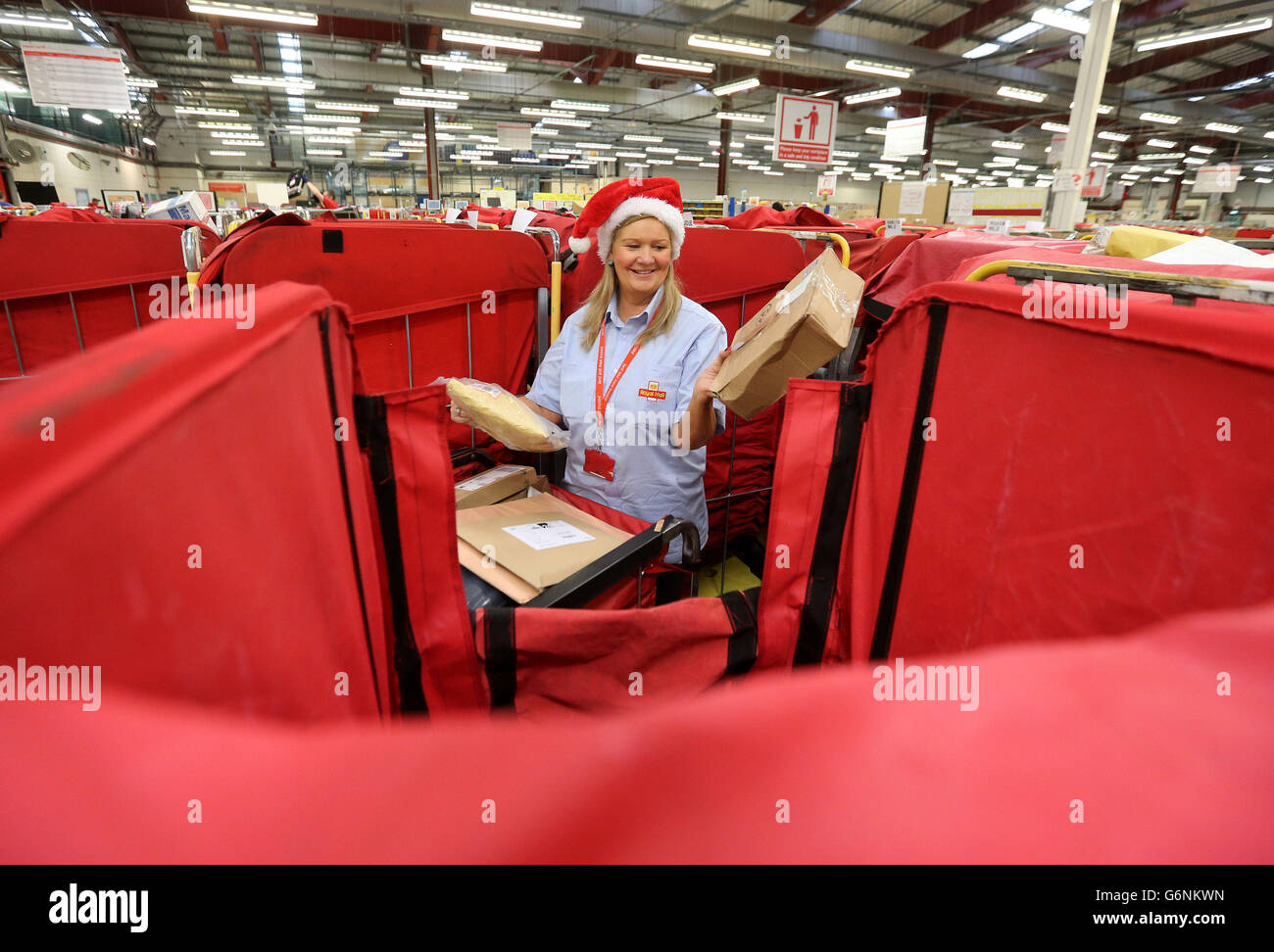 Royal Mail-Mitarbeiter June Gilliam, mit Weihnachtspost im Glasgow Mail Center, während des geschäftigsten Tages von Royal Mail im Jahr, an dem die Mitarbeiter erwarten, bis zu 2.8 Millionen Poststücke zu bearbeiten, während sie arbeiten, um sicherzustellen, dass die Post rechtzeitig für Dezember 25 ankommt. Stockfoto