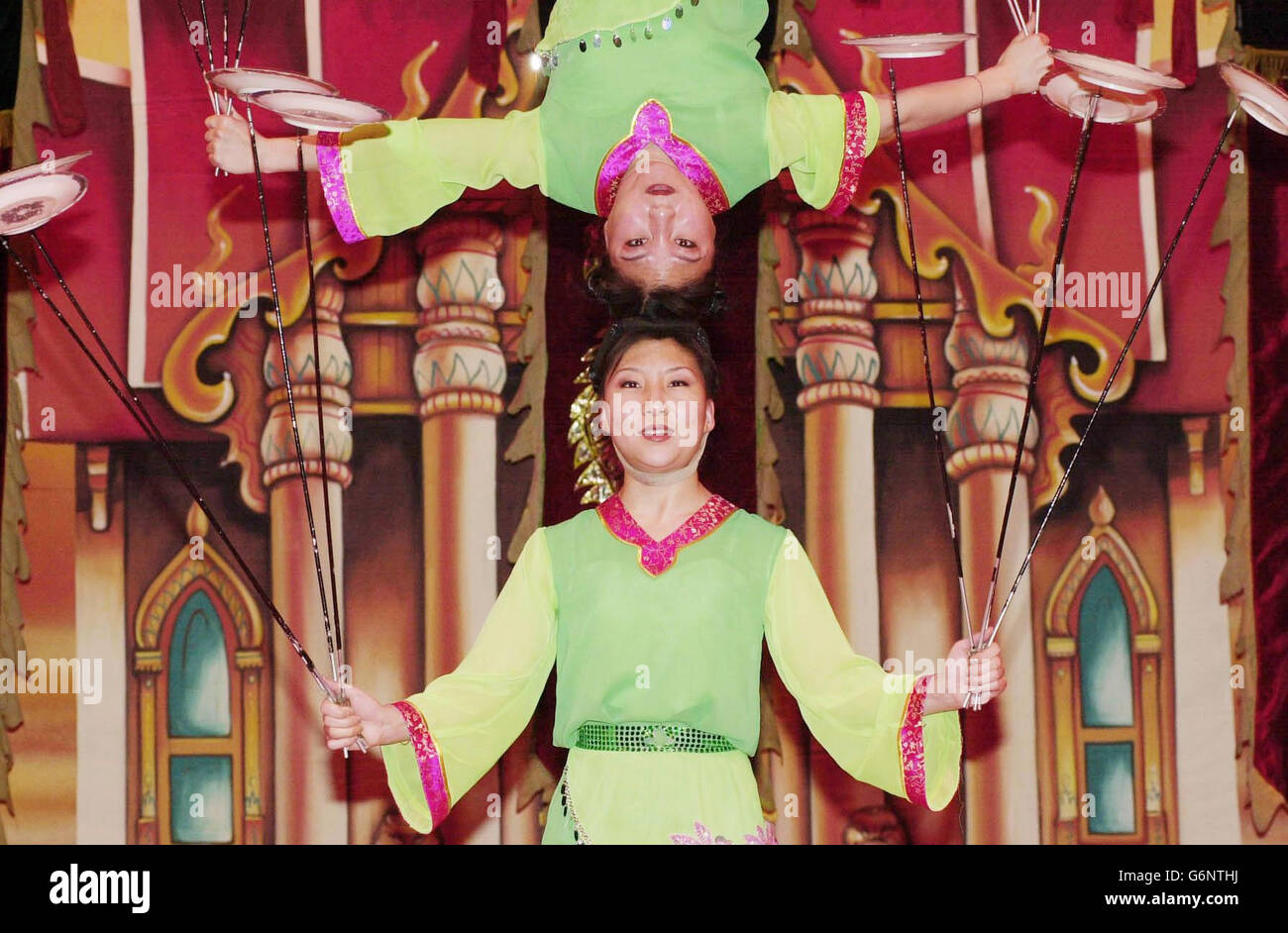 Gao Ding (oben) balanciert auf dem Kopf ihrer Zwillingsschwester, Gao Ning, während beide während einer privaten Vorschau der neuen Show des Chinese State Circus in der Queen Elizabeth Hall am Londoner South Bank Platten drehen. Der international renommierte Zirkus, in dem sich 30 der größten und felxibelsten Zirkusartisten Chinas befinden, wird bis zum 2. Januar 2004 in der Hauptstadt laufen. Stockfoto