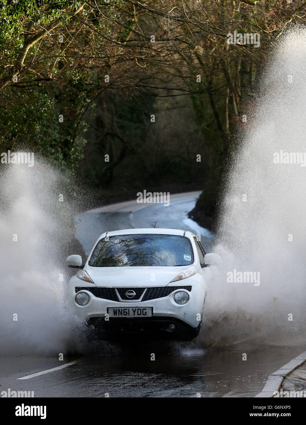 Ein Auto fährt durch eine überflutete Straße in der Nähe von Yalding, Kent, während mehr heftige Regen über das Land fegt. Bilddatum: Montag, 30. Dezember 2013. Siehe PA Geschichte WETTER Weihnachten. Bildnachweis sollte lauten: Gareth Fuller/PA Wire Stockfoto